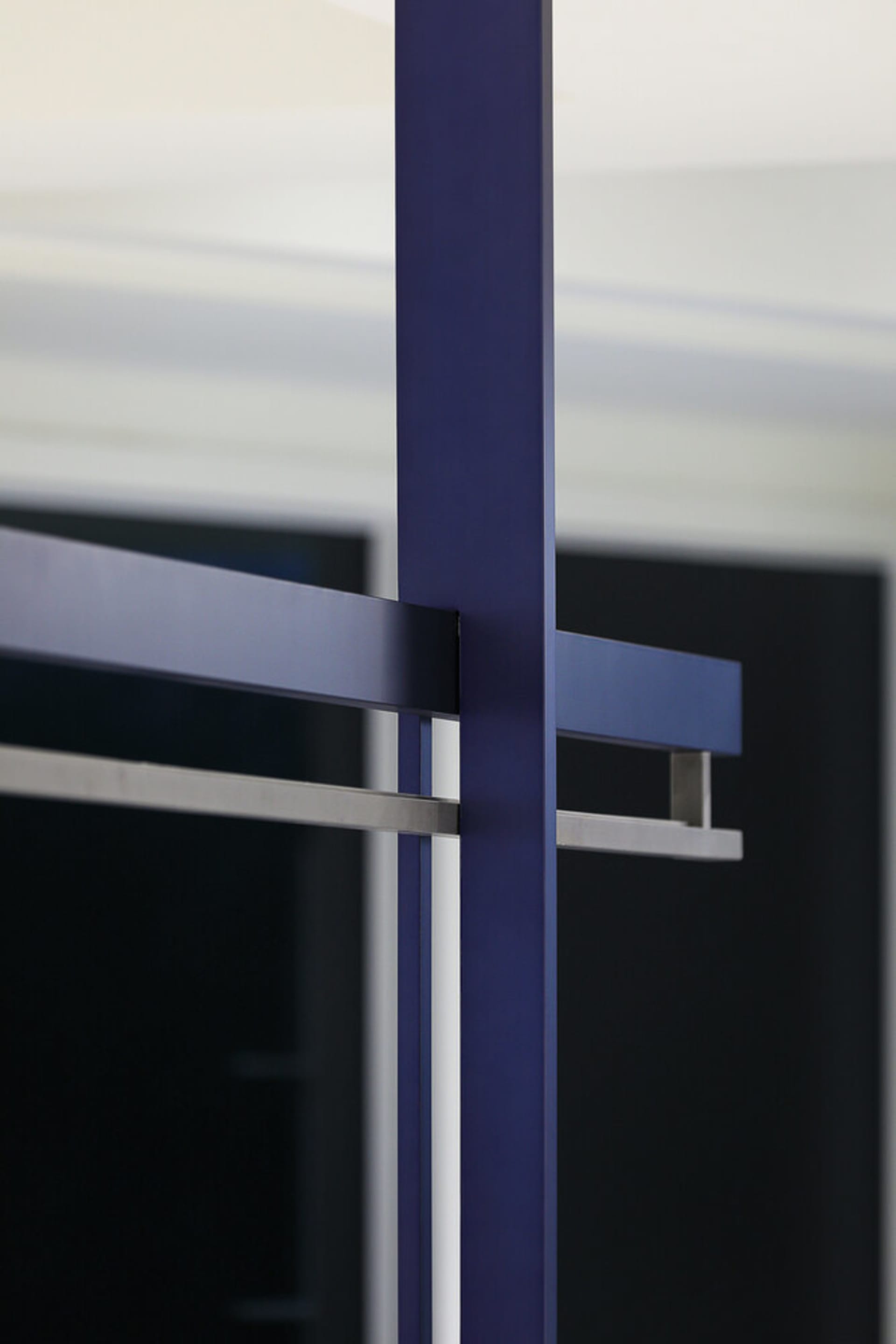 A minimalist architectural structure featuring metallic and glass components.
