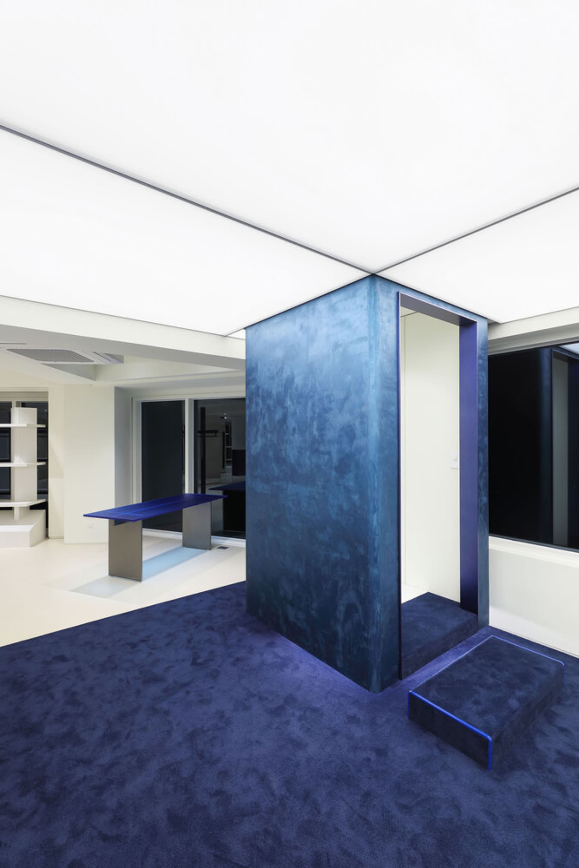 A minimalist interior with concrete walls and blue accents.