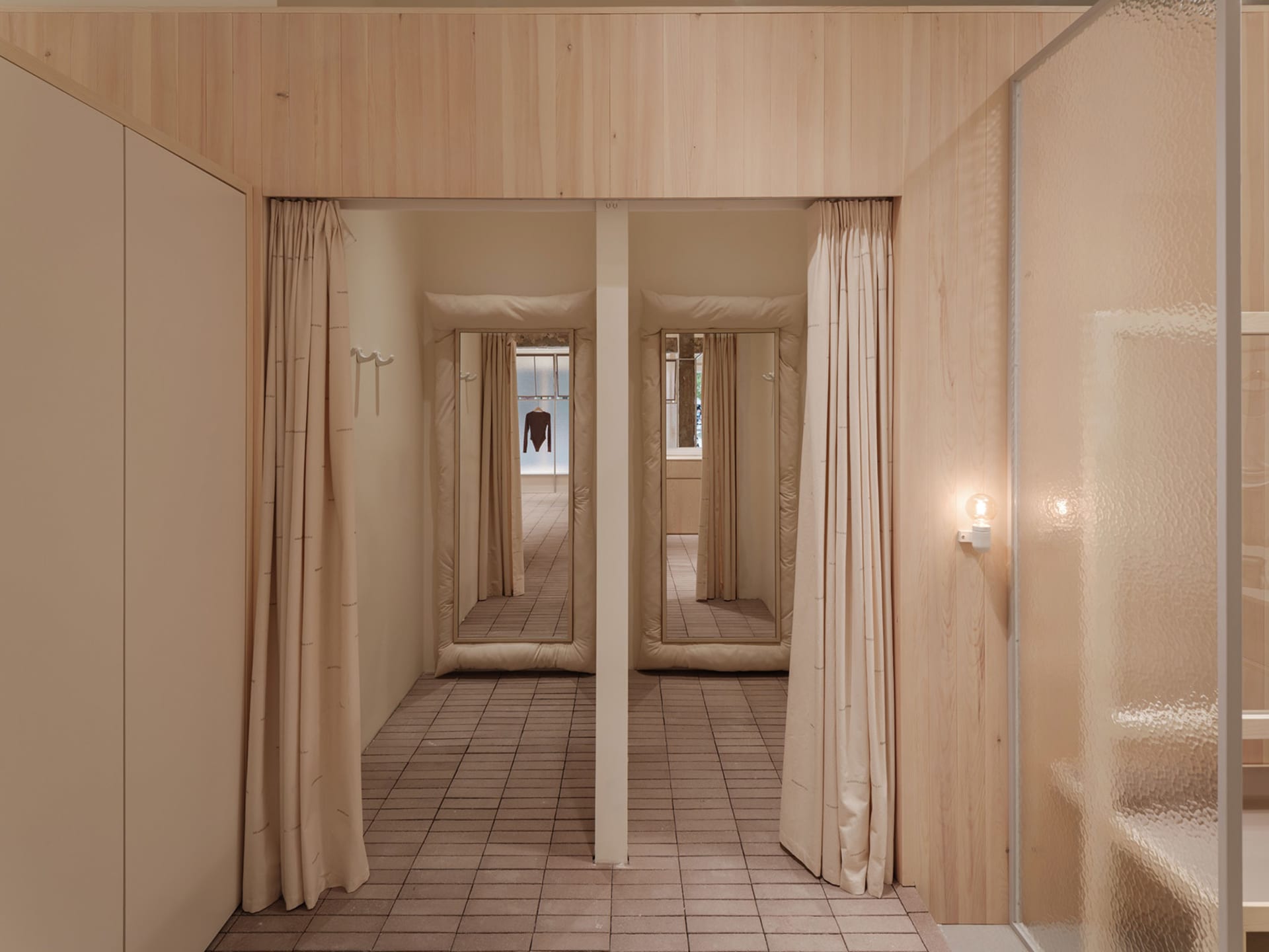 A modern fashion retailer clothing shop with shelves and mirrors.