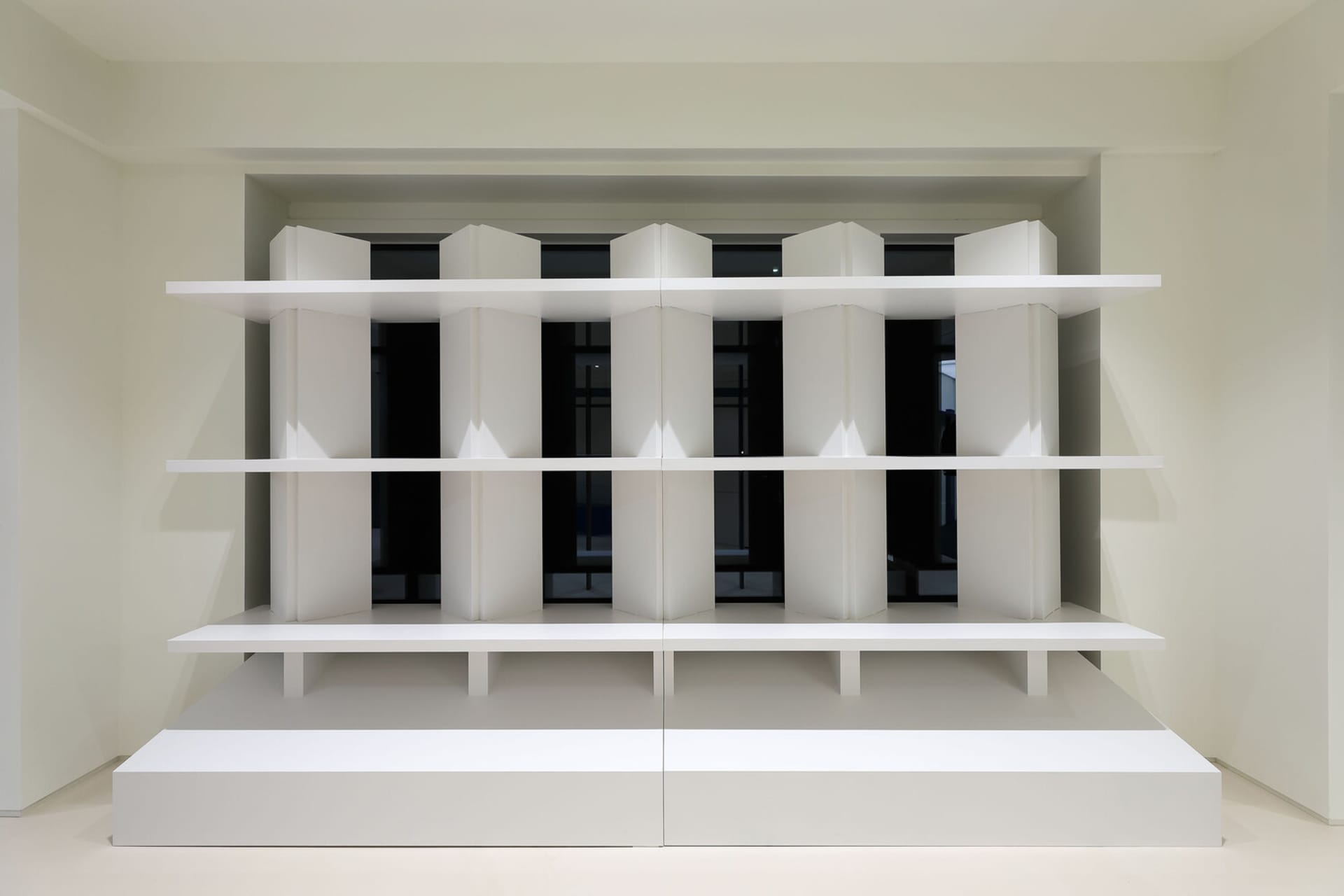 A modern, minimalist interior with white shelves and structural elements.