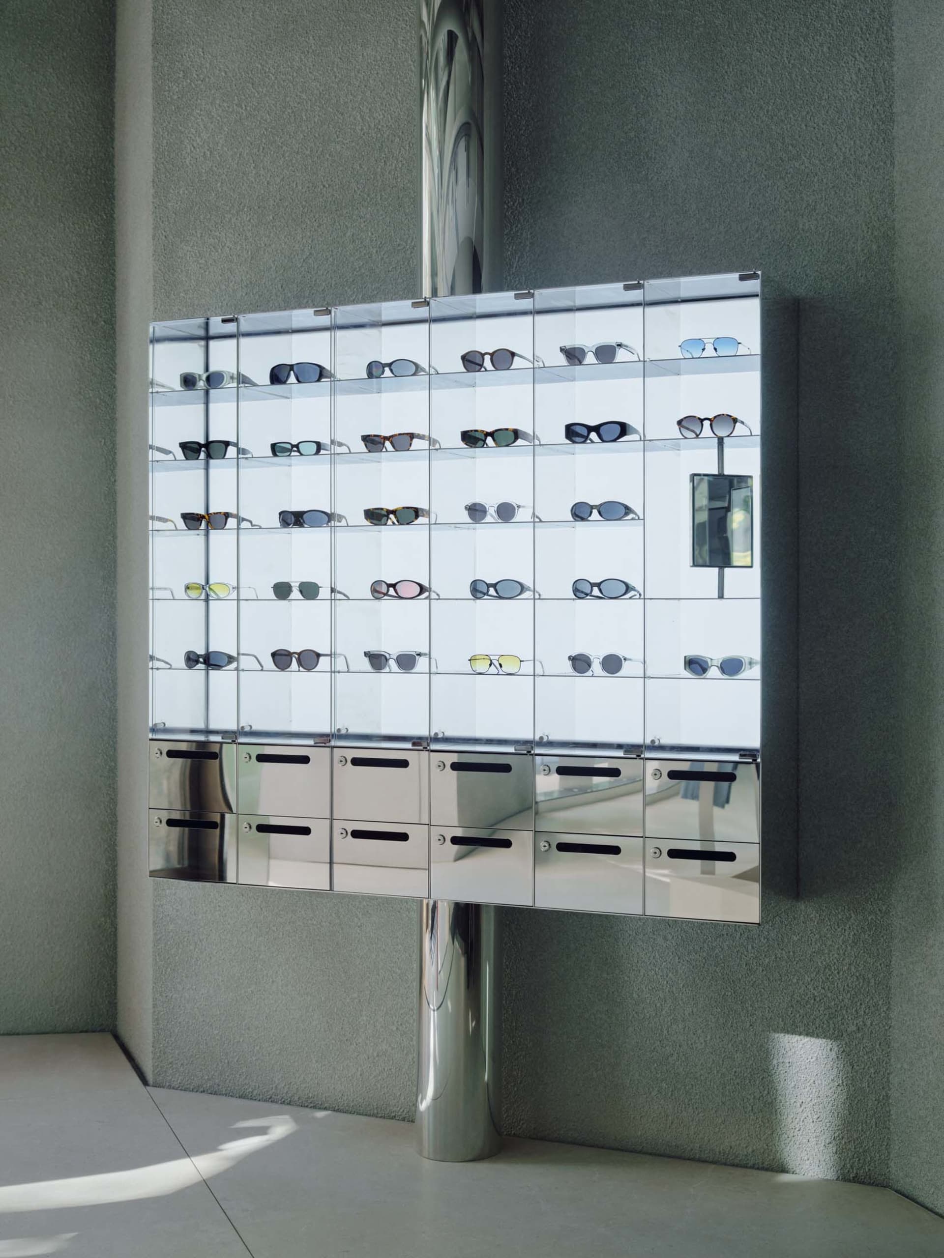 A glass display case filled with various sunglasses arranged neatly on shelves.