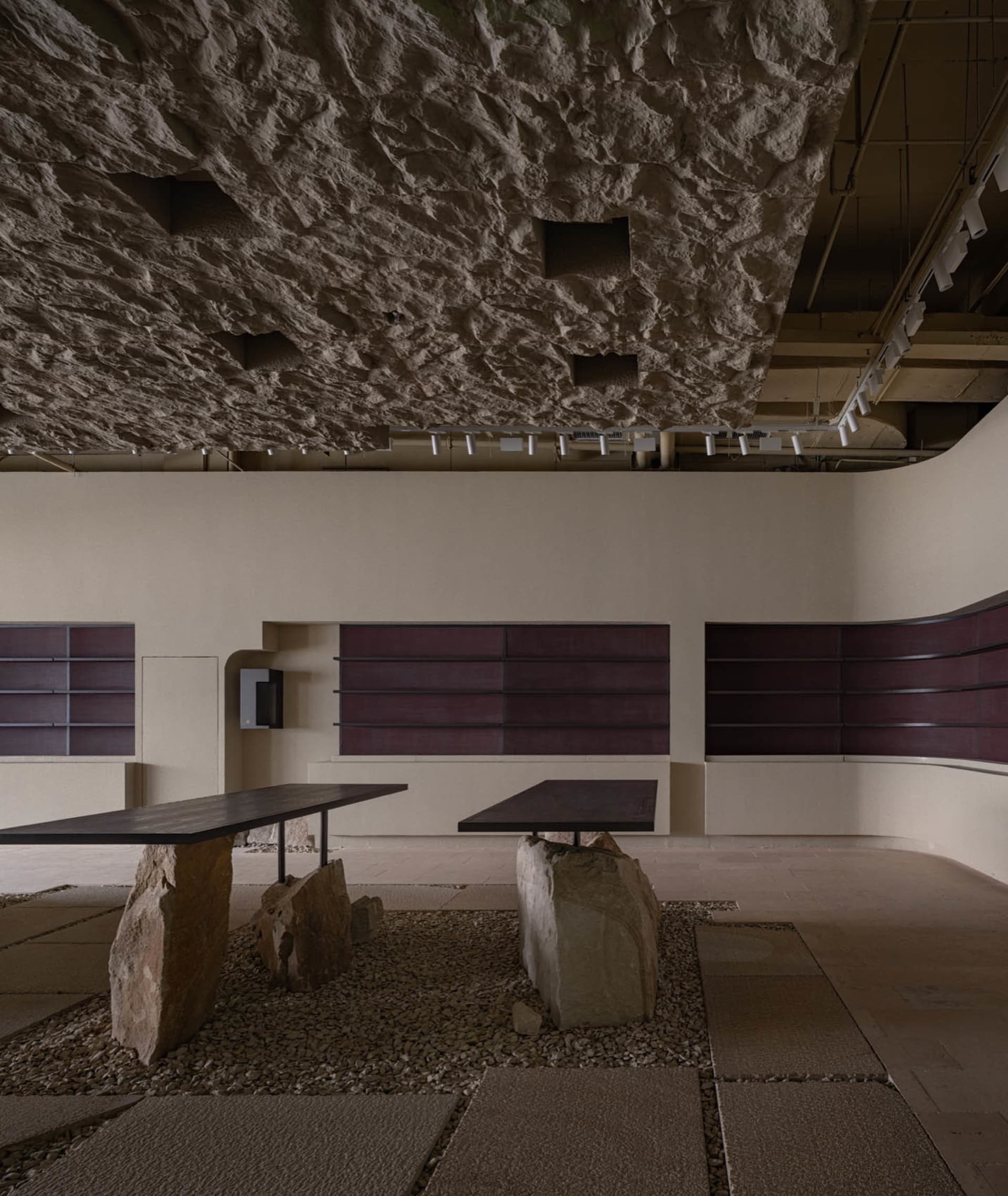 Minimalist cafeteria with terrazzo flooring and stone tables.