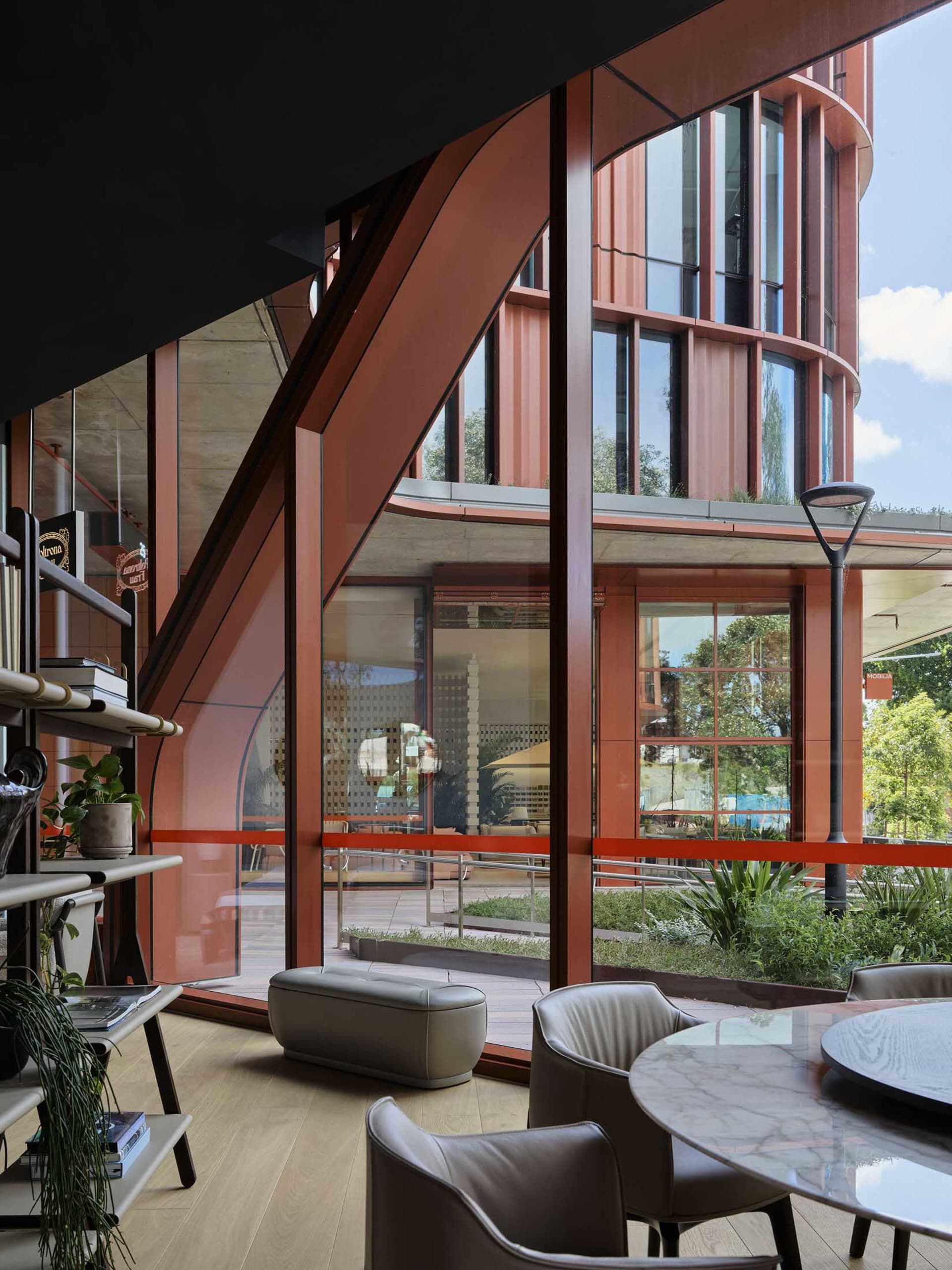 A modern lounge with brick and concrete walls and a glass table.