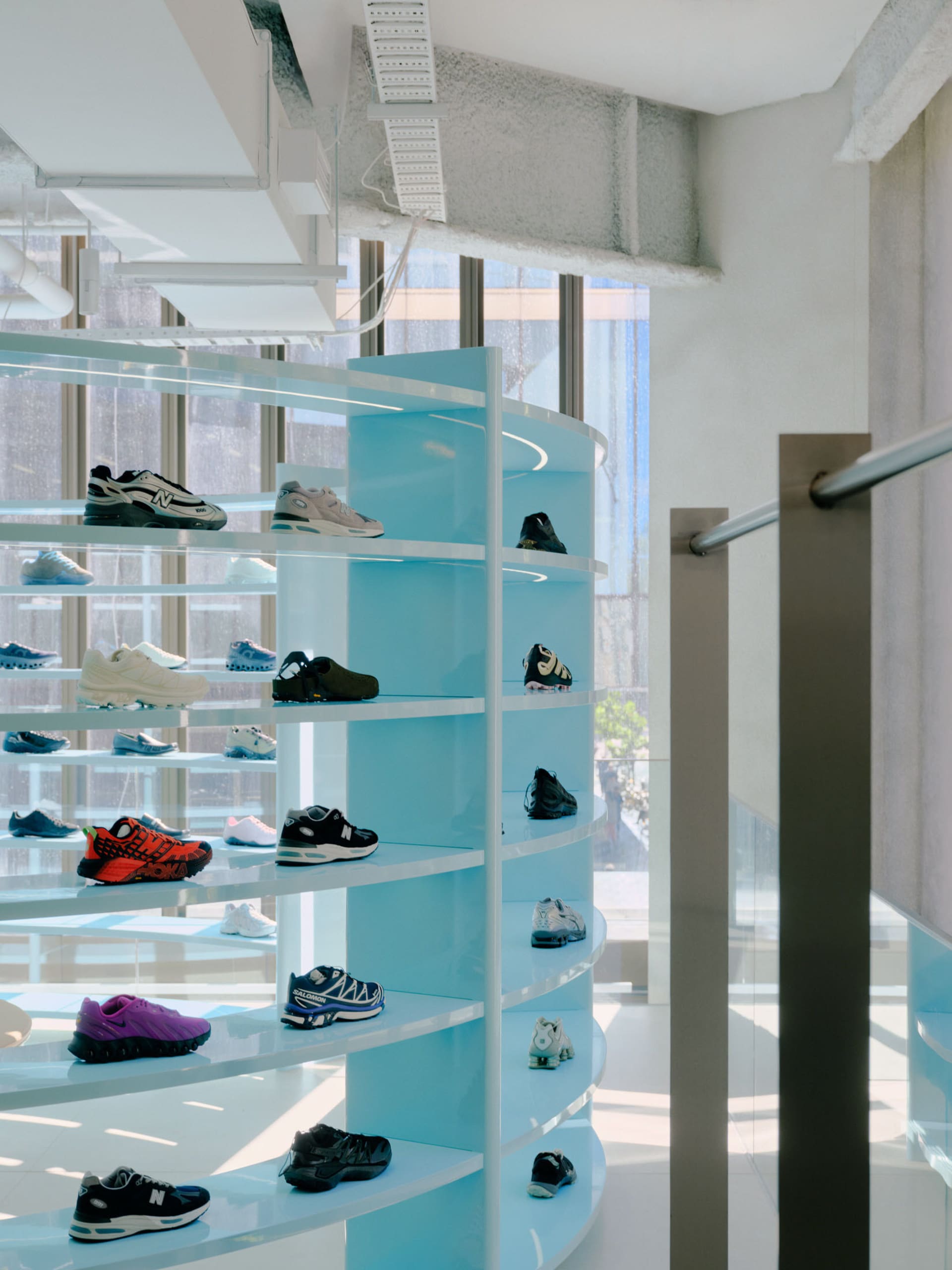 A modern shoe store with blue shelves displaying various shoes.
