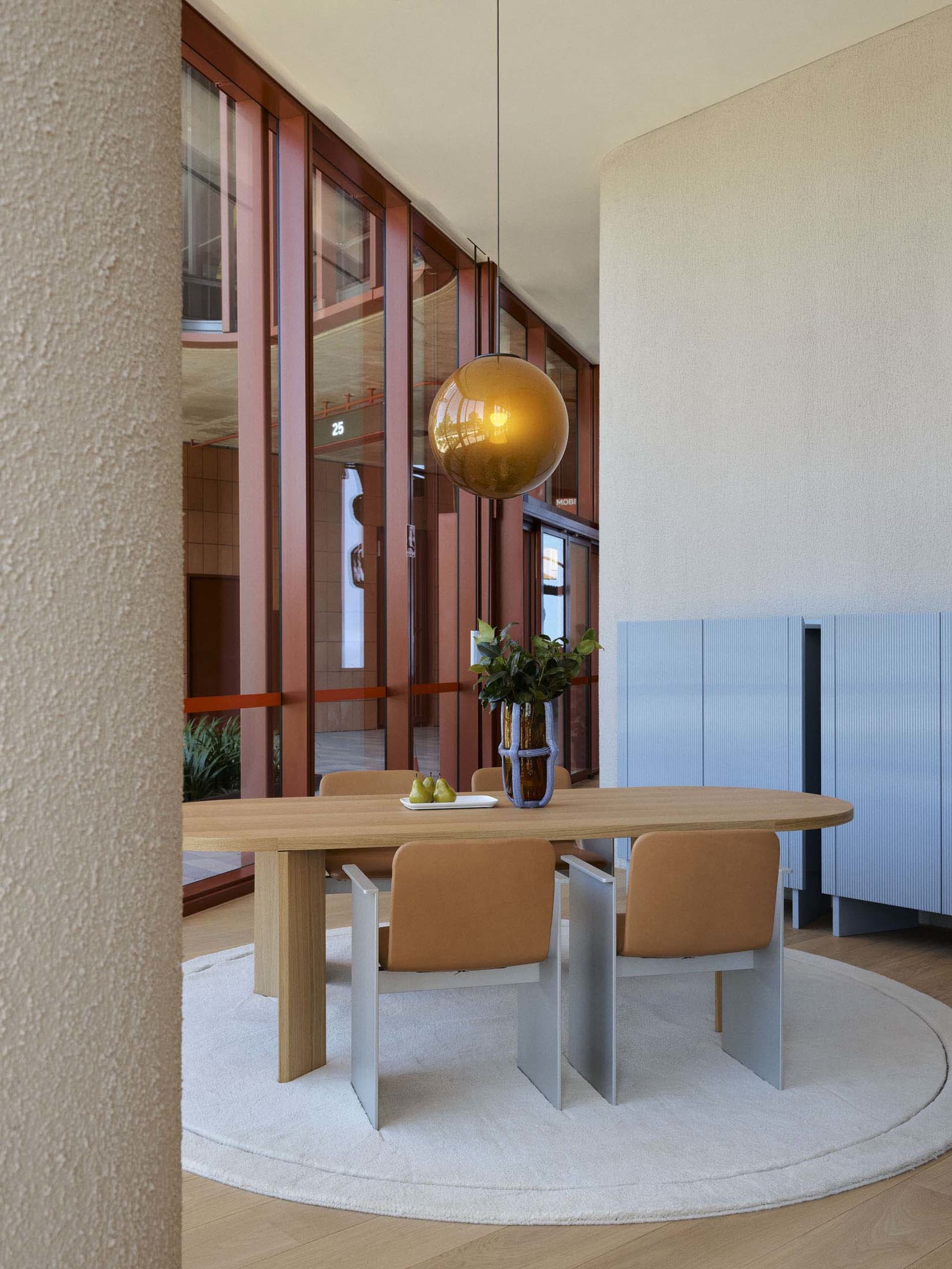 Modern dining room with wooden table, metal chairs, and glass pendant light.