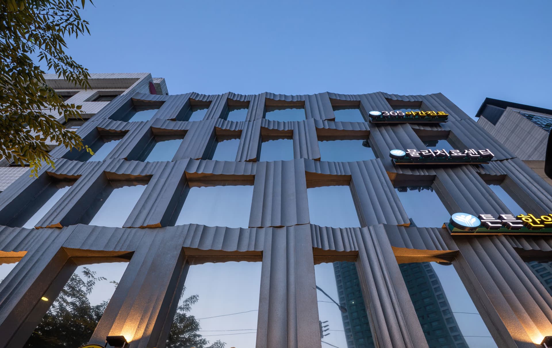 一座現代建築,擁有金屬立面與反光玻璃窗。