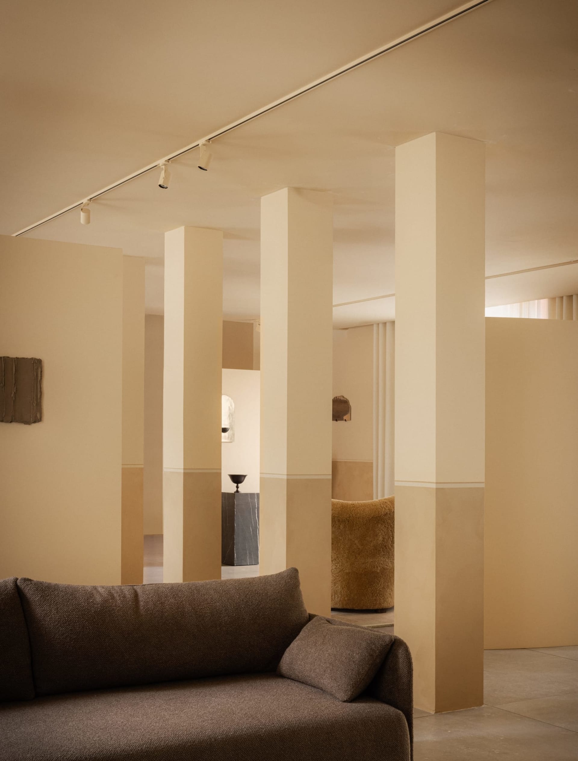 A modern living room with neutral-colored walls and furniture, featuring minimalistic design elements and a sense of openness