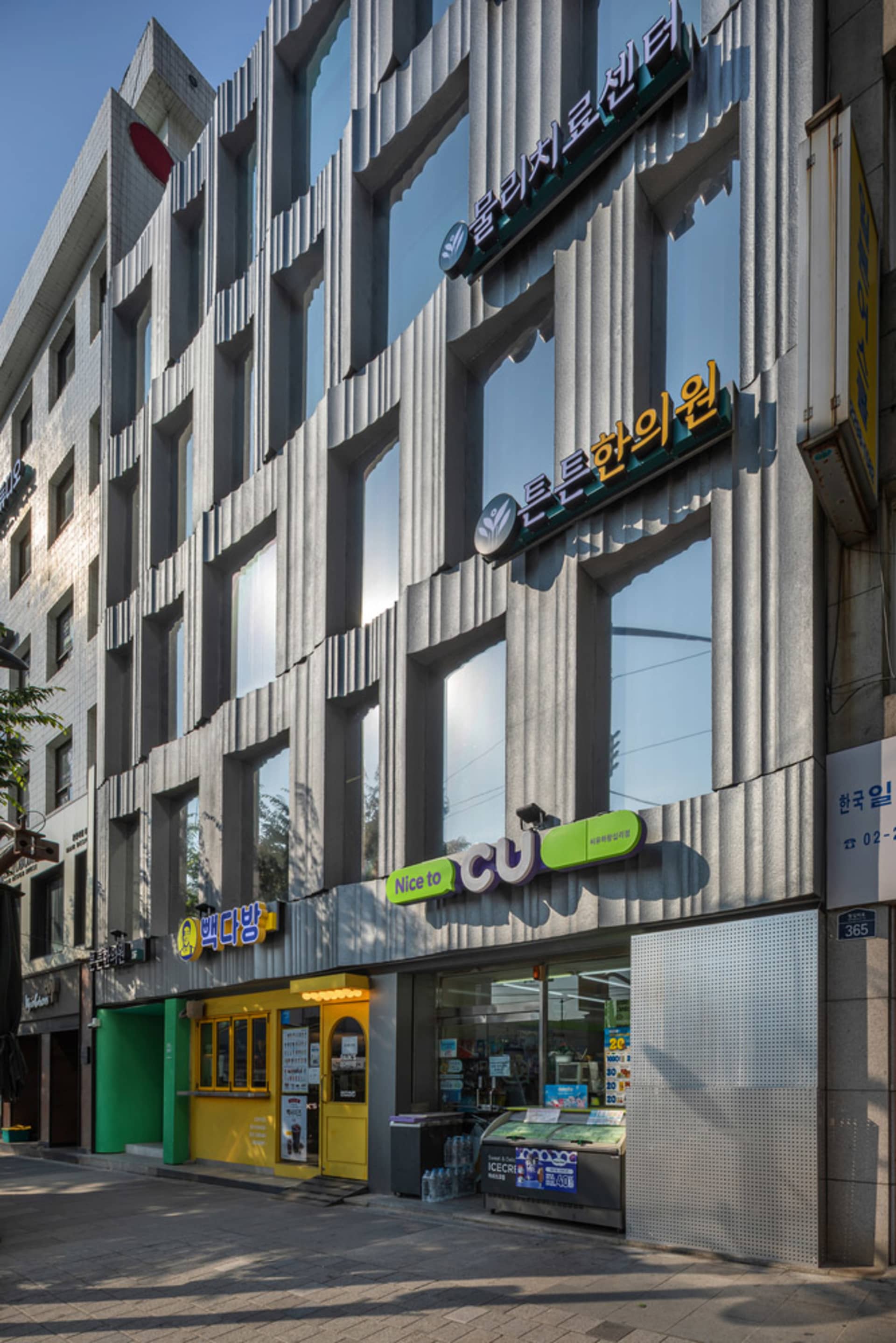 現代都市店面採用金屬包覆與玻璃立面