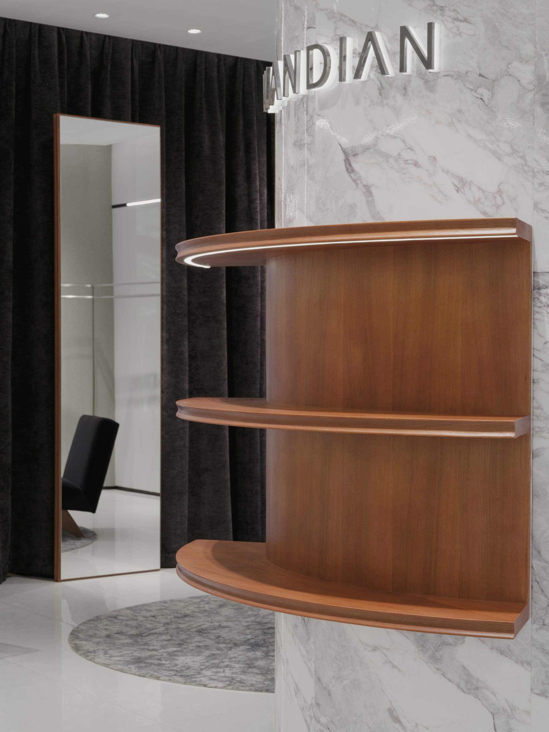 A modern interior design featuring a wood shelf with a curved edge, illuminated by LED lighting, against a white marble wall.