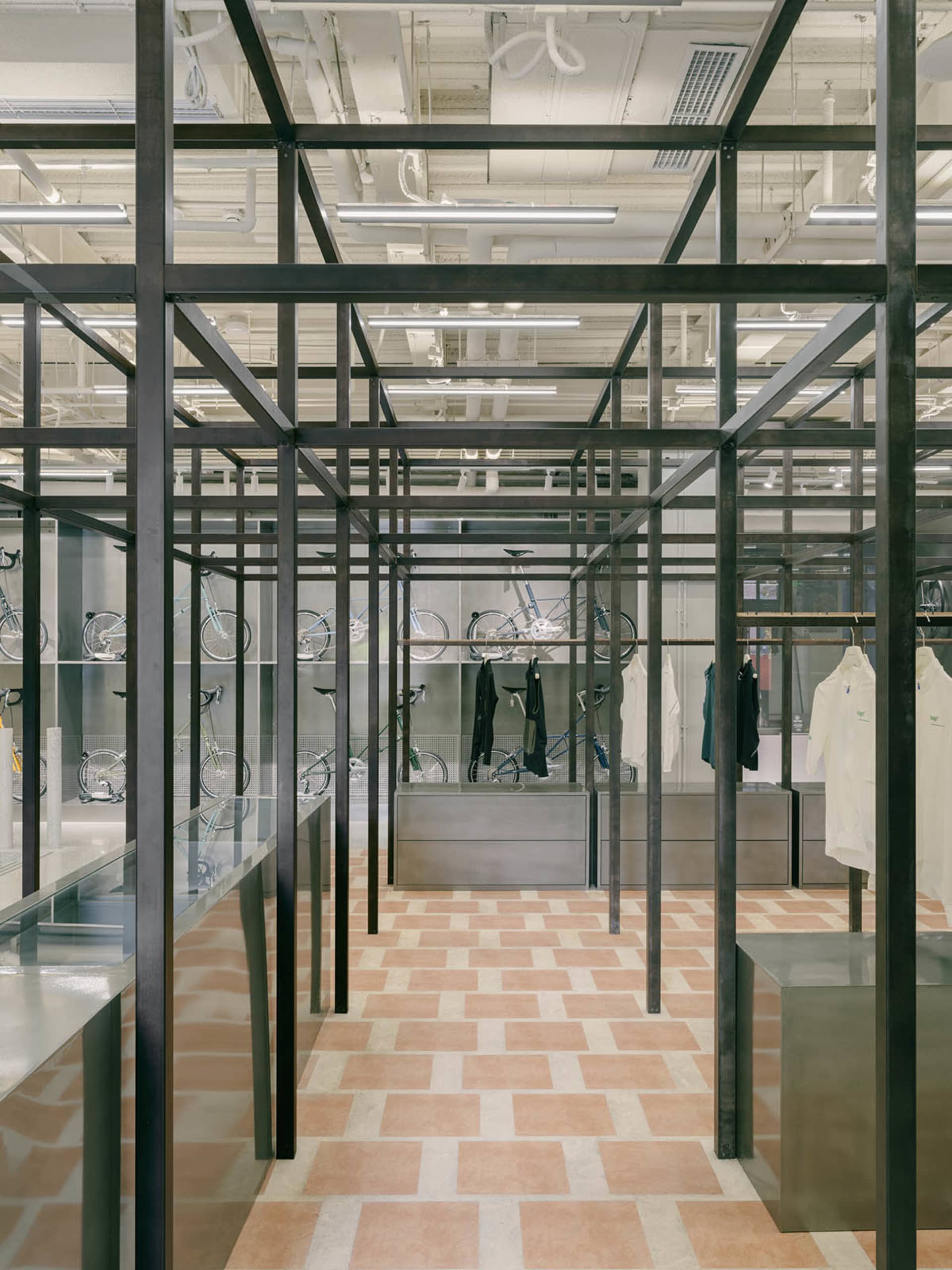 Industrial-style retail store with metal framing and large glass showcases displaying bicycles.