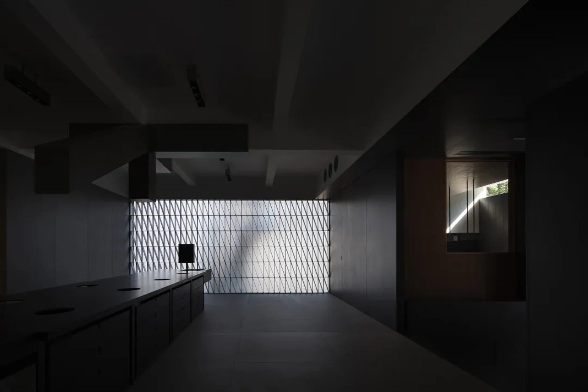 A modern industrial office with a metal mosaic tile wall and dark interior design elements.