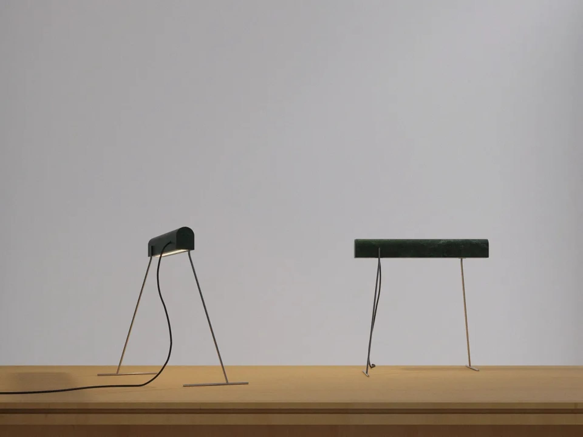 A modern desk lamp with a marble base, lying flat on a wooden surface.