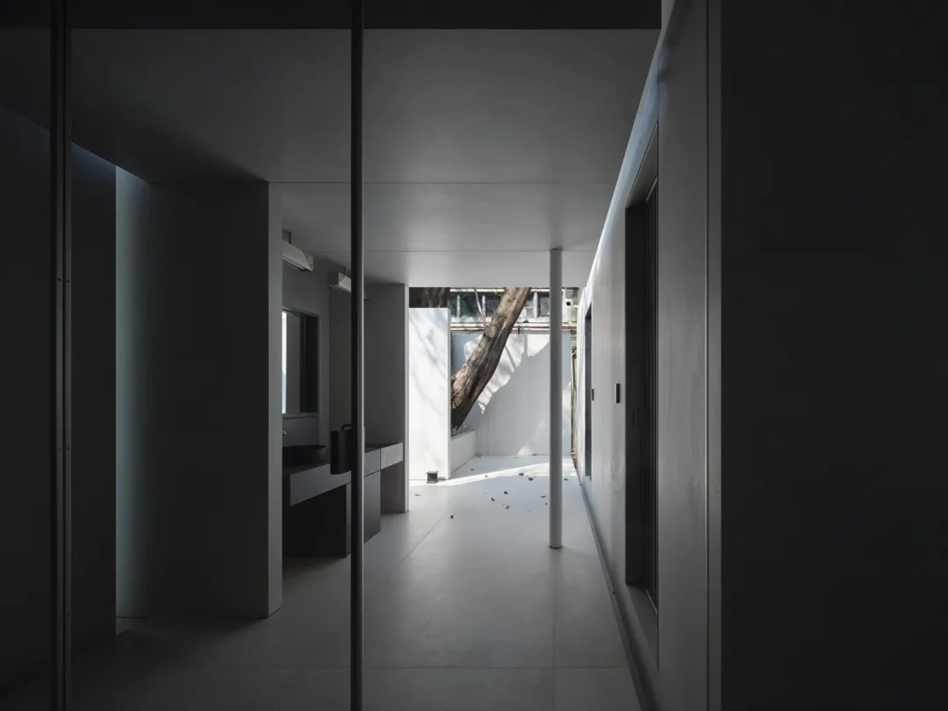 A minimalist living room featuring concrete walls and modern furniture.