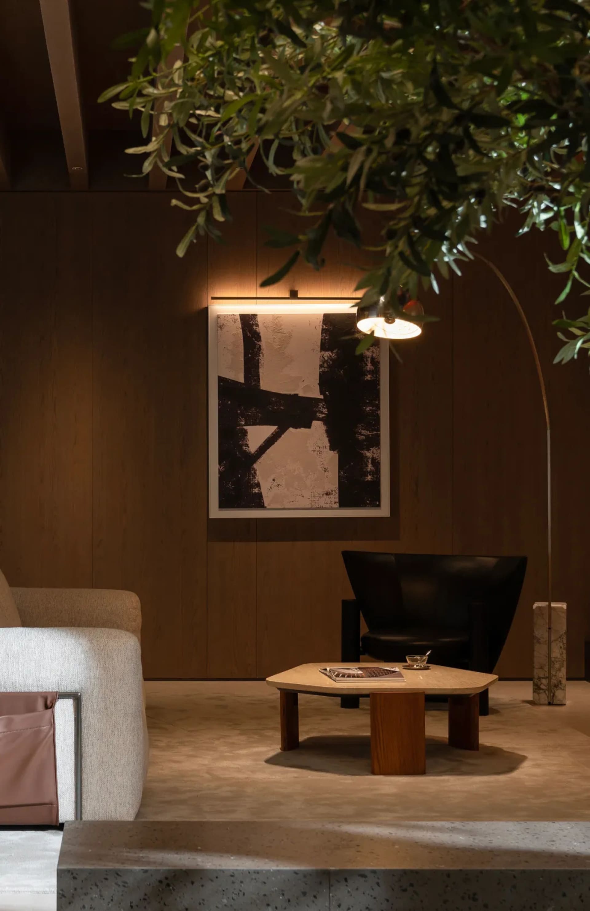 Modern living room interior featuring a sleek leather chair, a wooden coffee table, and minimalist artwork on the wall.