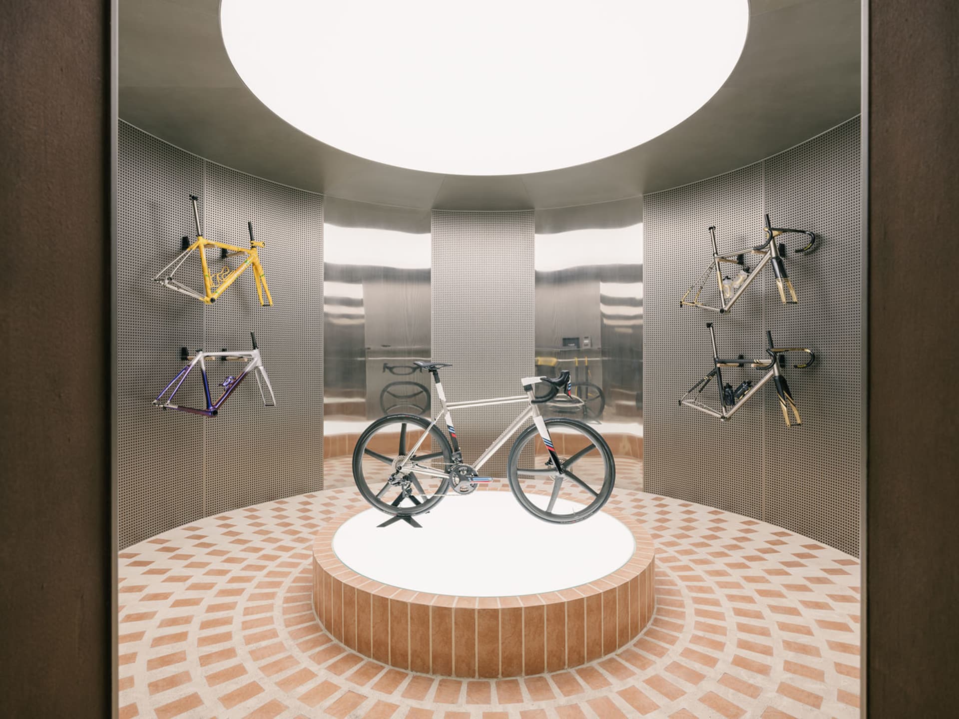 A bicycle showroom with metallic frames and a circular design layout.