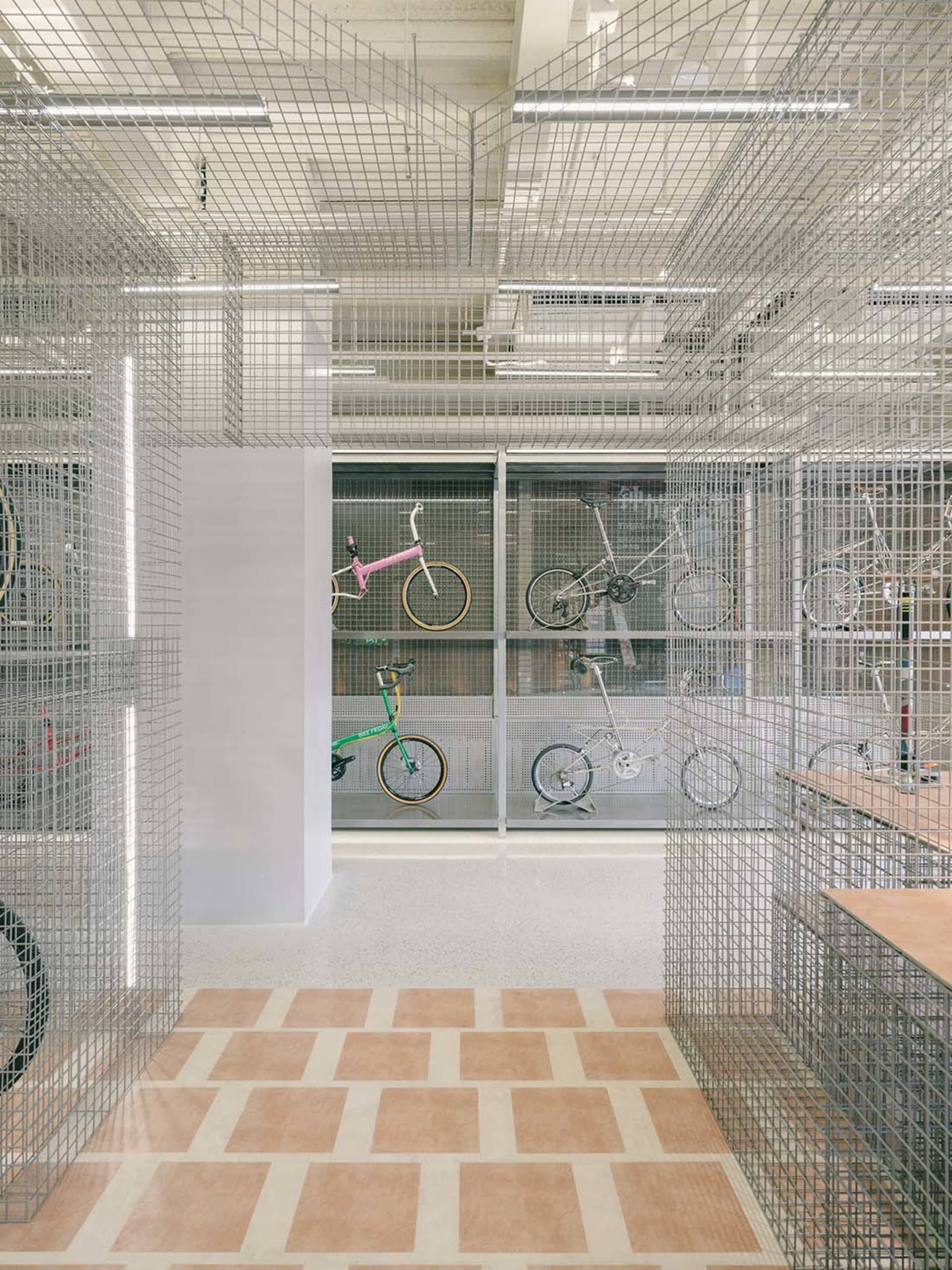 A modern interior space featuring metal grid storage for bikes.
