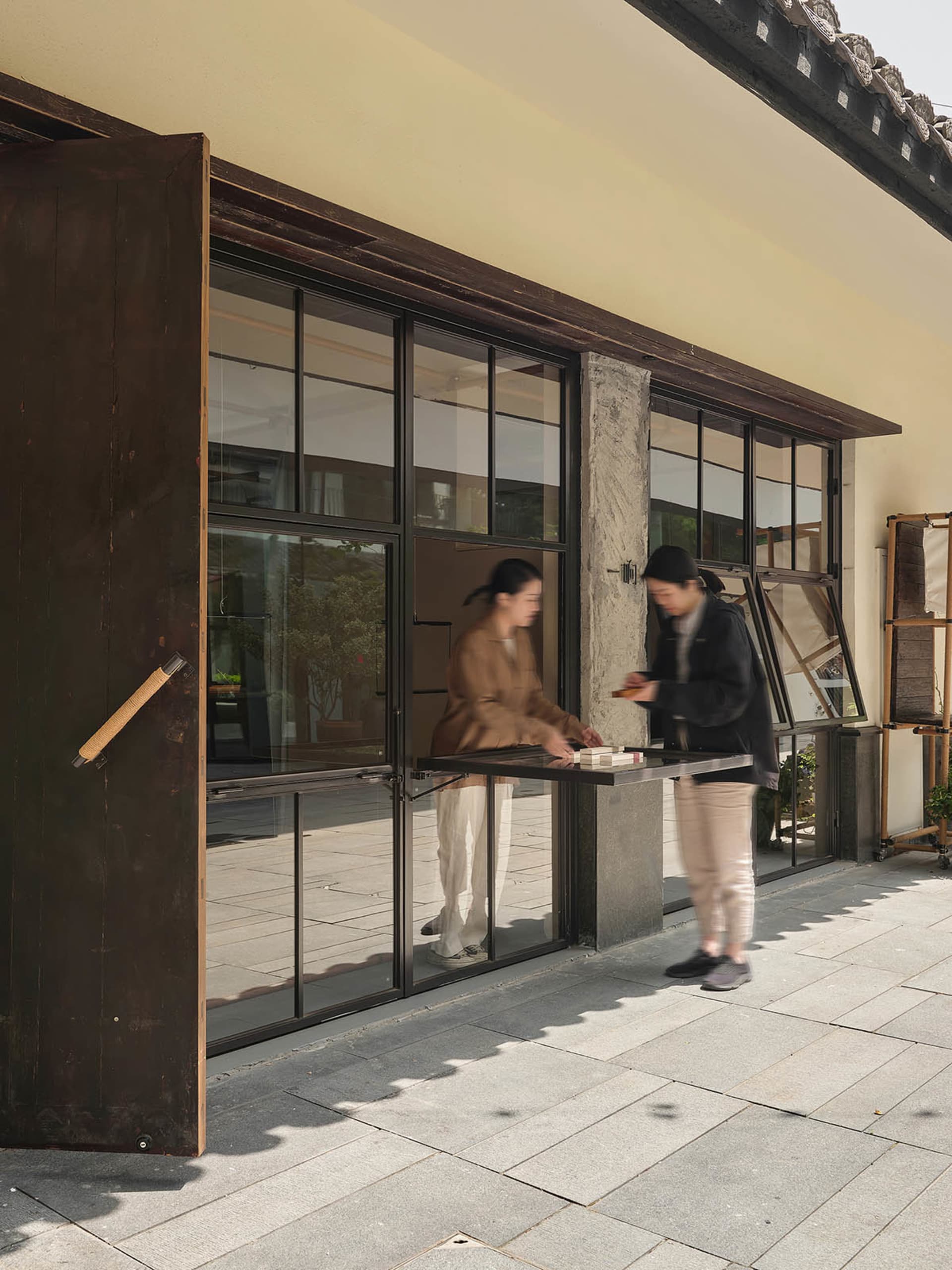 A modern storefront with large glass windows and wooden accents.