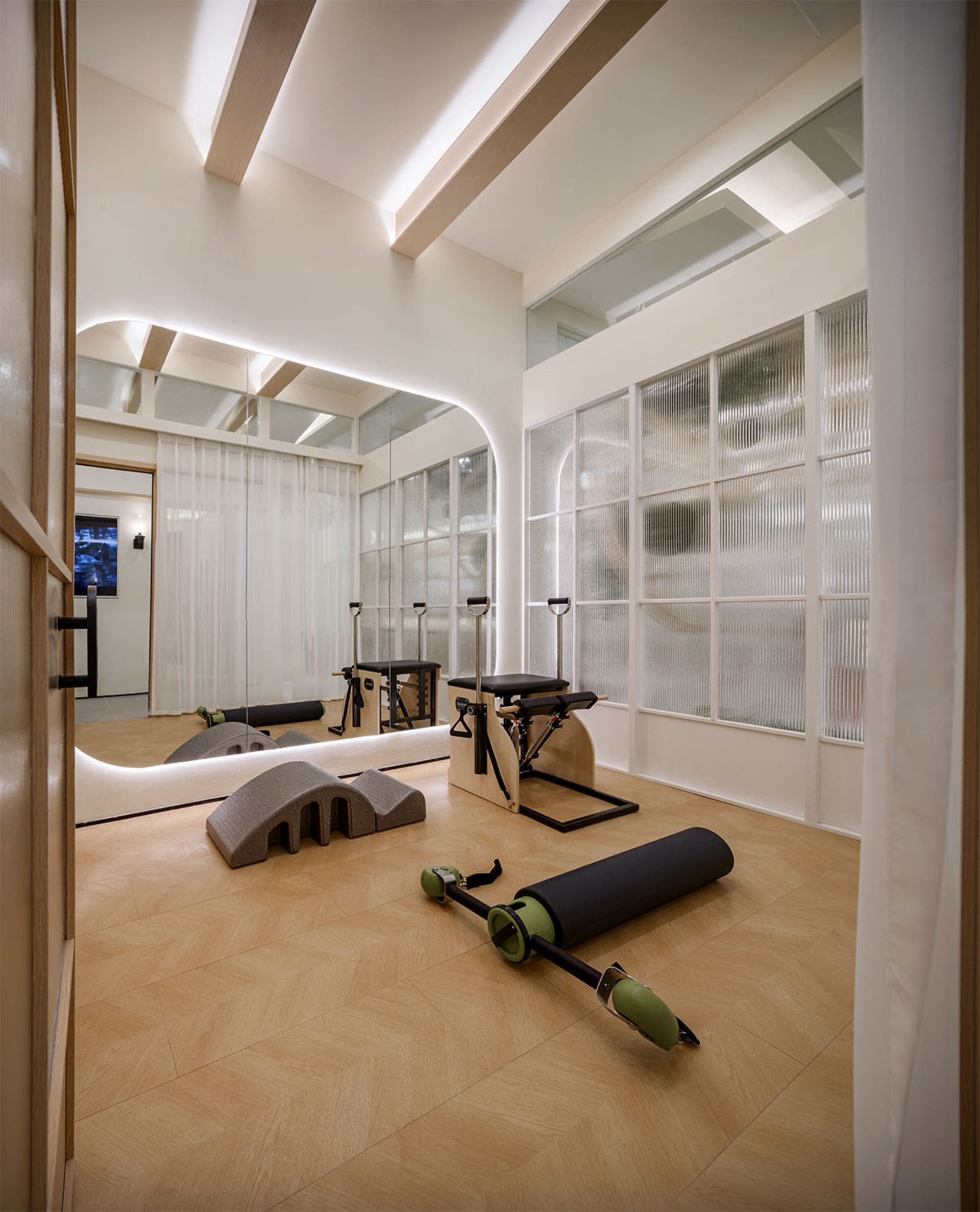 A minimalist exercise room with wooden flooring and equipment.