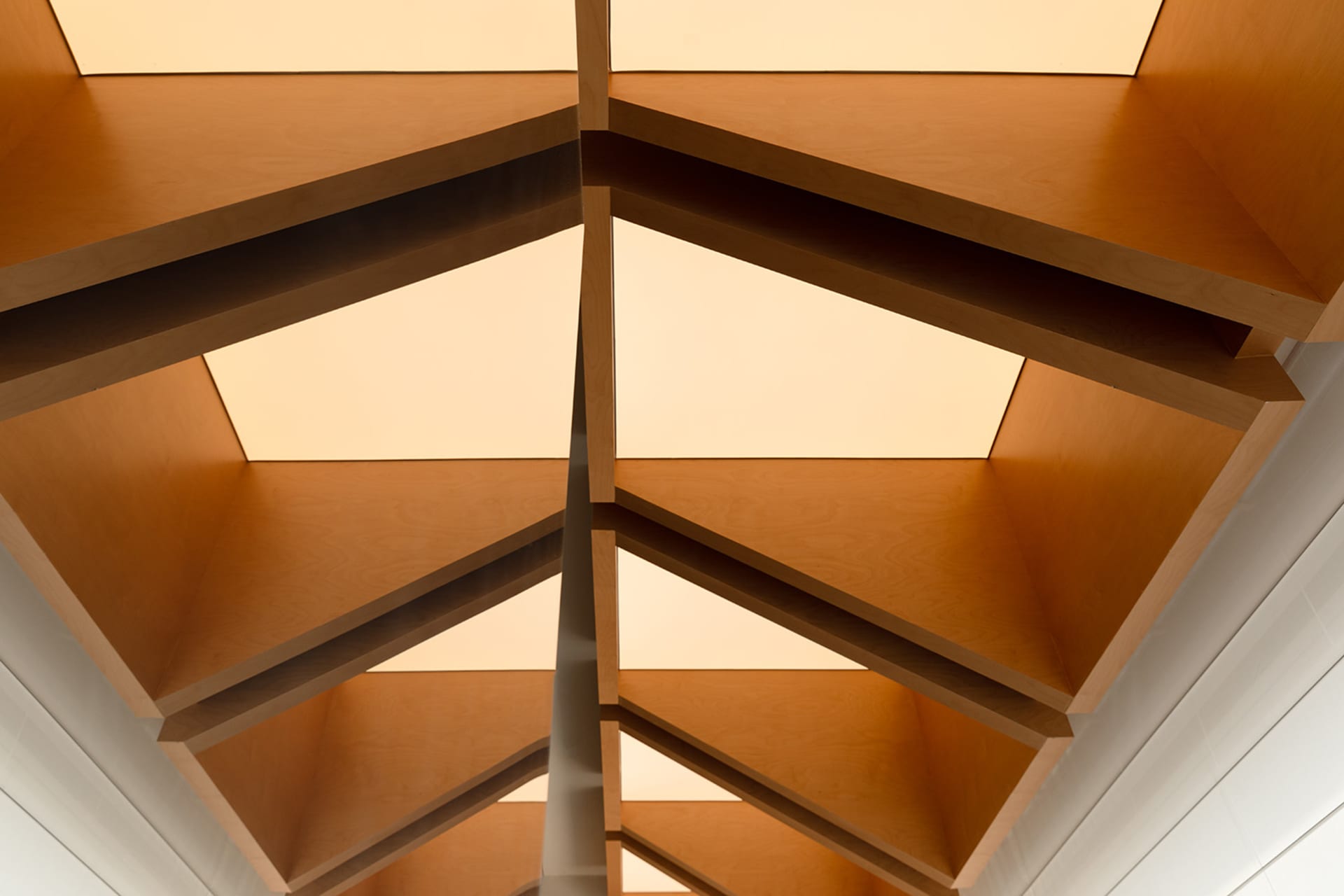 A sleek, modern interior with a geometric metal ceiling structure.