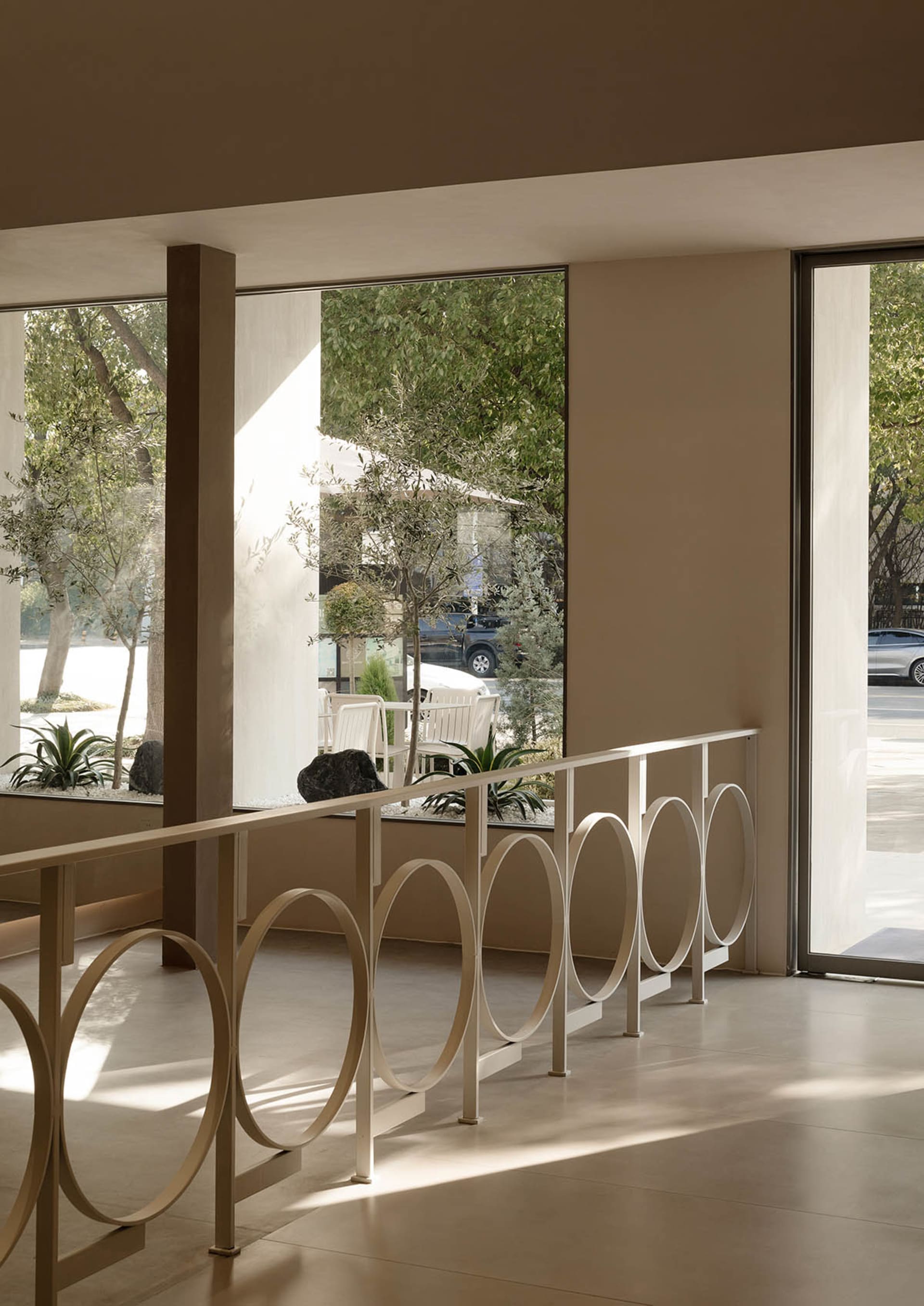 Modern restaurant interior with concrete, glass, and wooden elements.