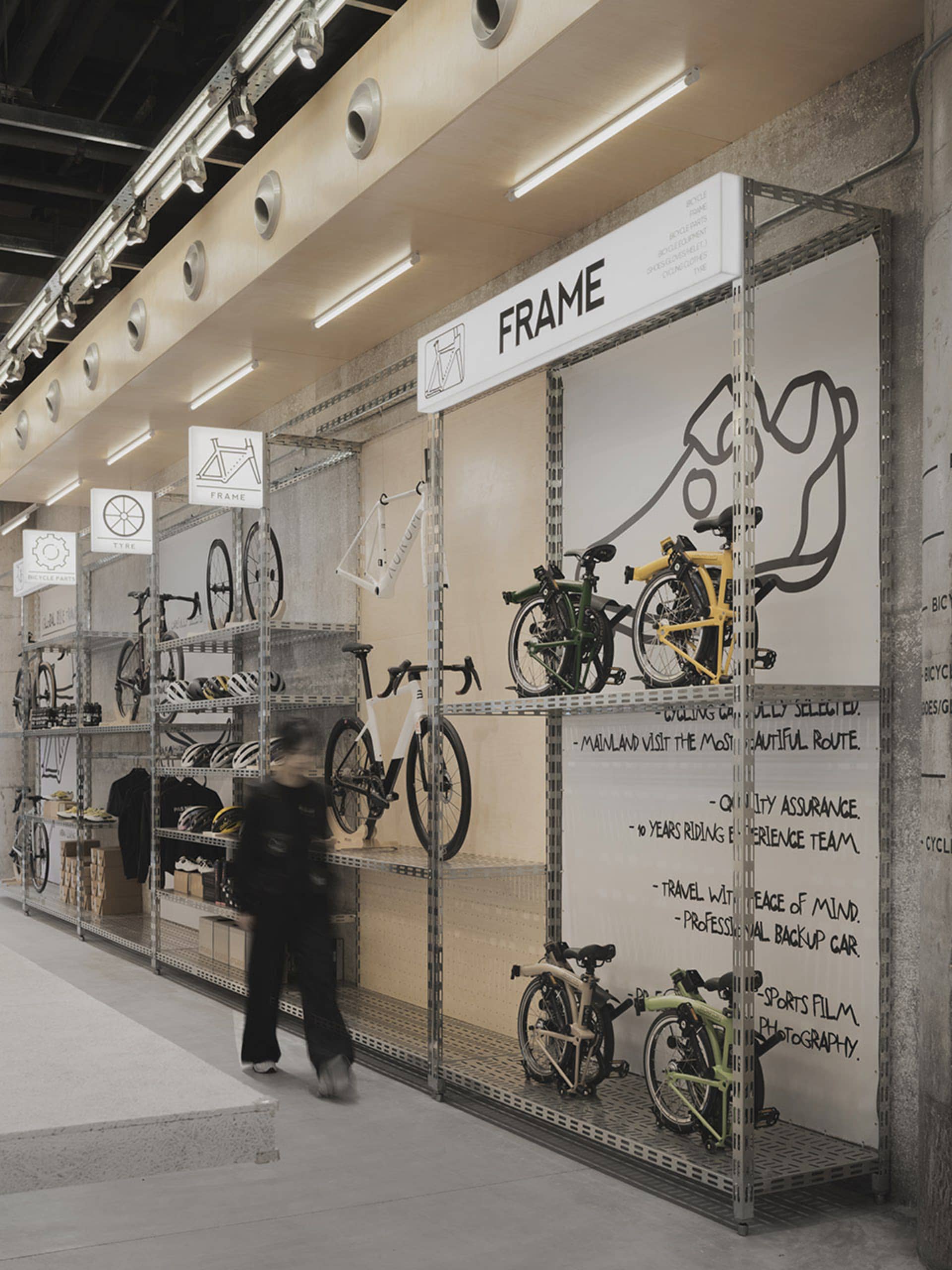 A modern bike store with metal shelves and concrete walls displaying various bicycles and accessories.