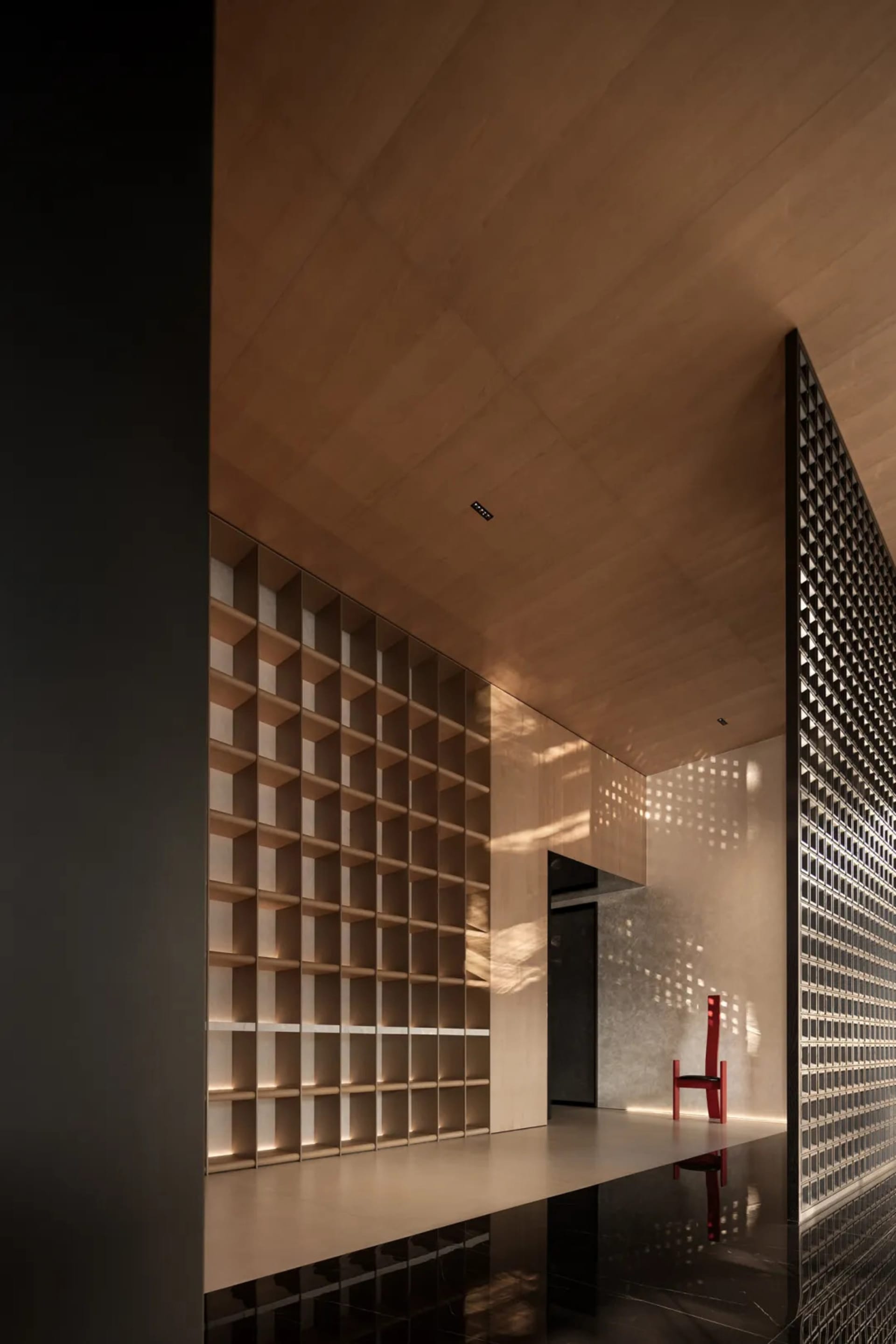 A modern interior space featuring wooden shelves and a red chair.