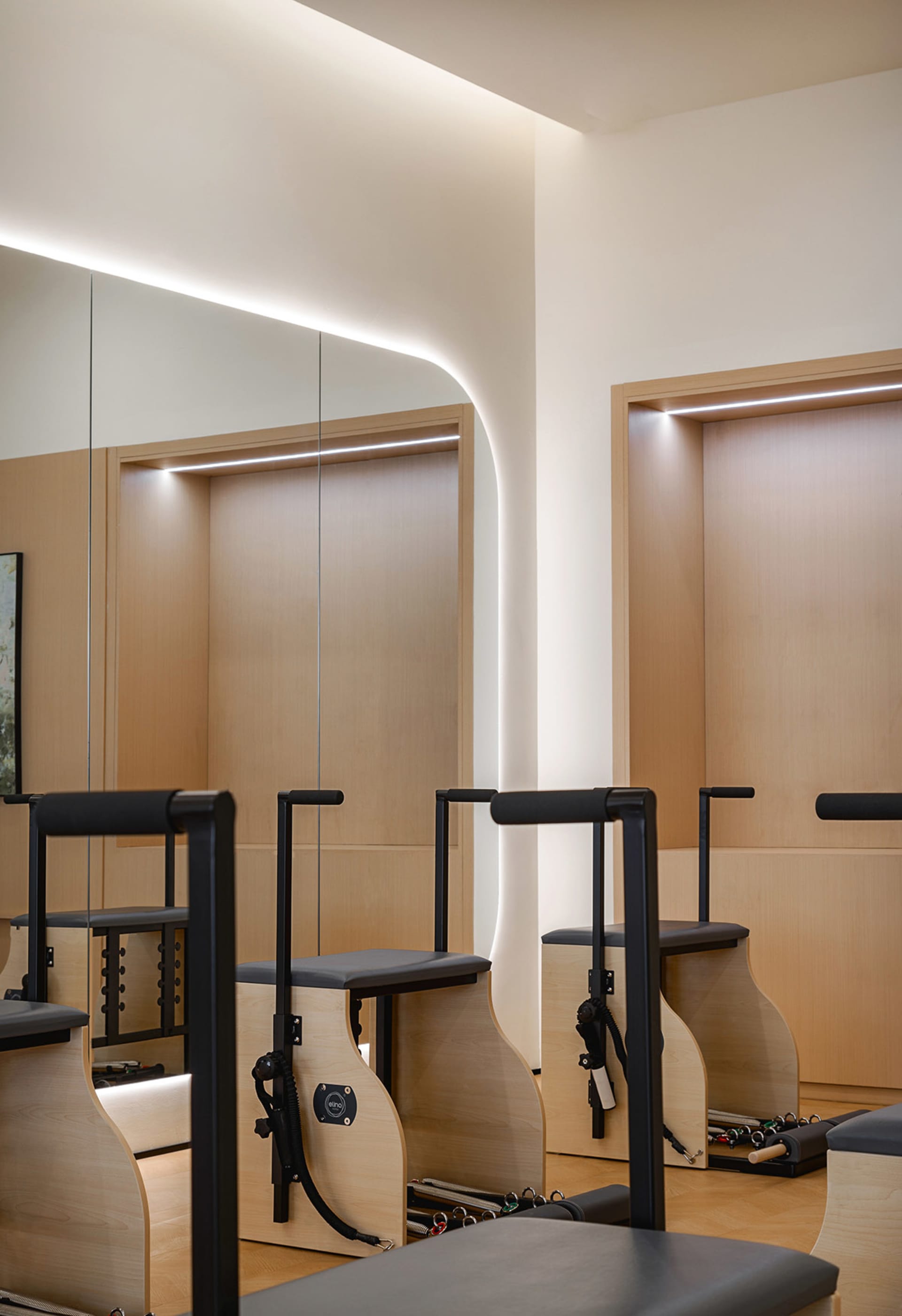 Modern Pilates studio with wooden furniture and workout equipment
