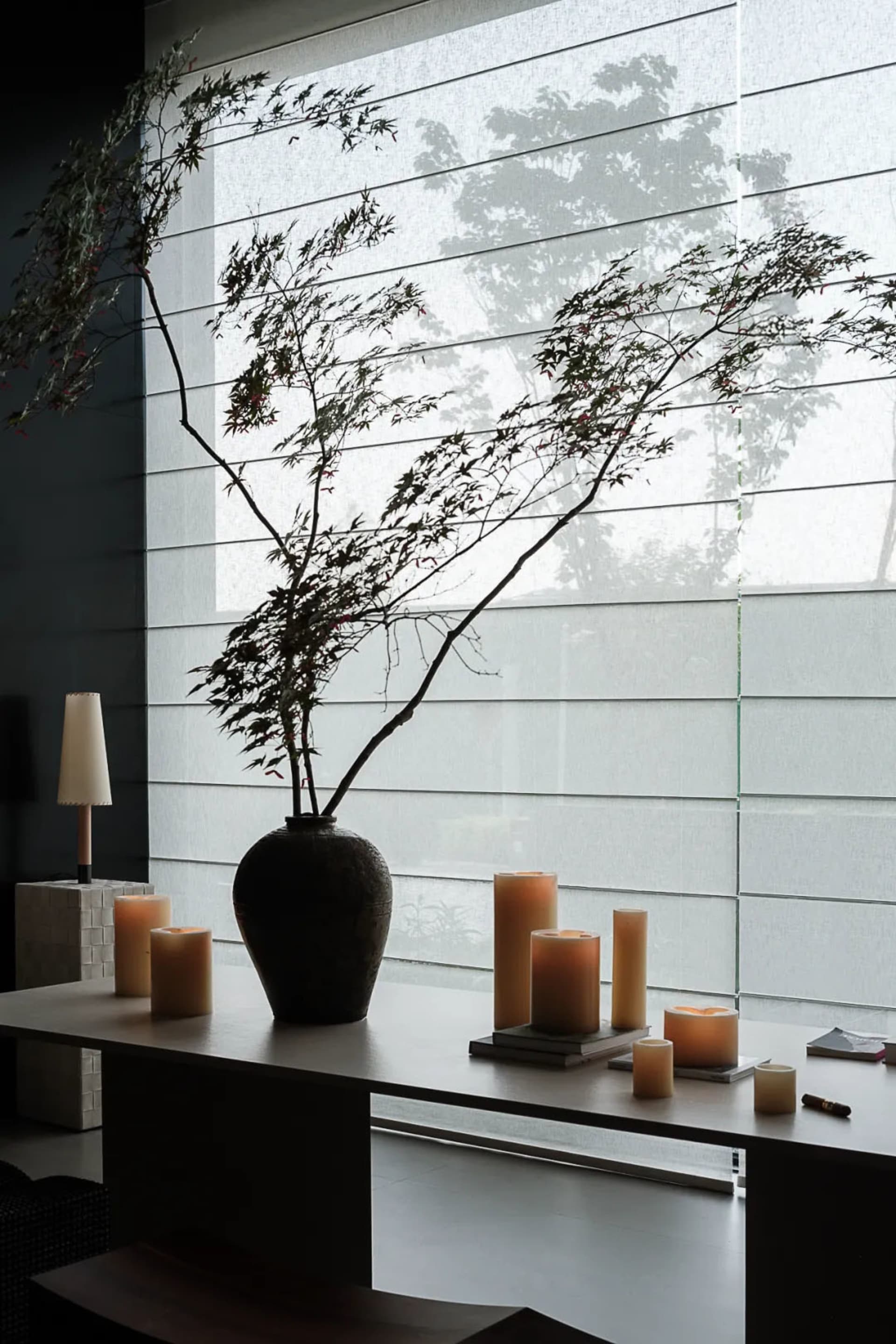 A minimalist interior space featuring a ceramic vase with a floral arrangement.