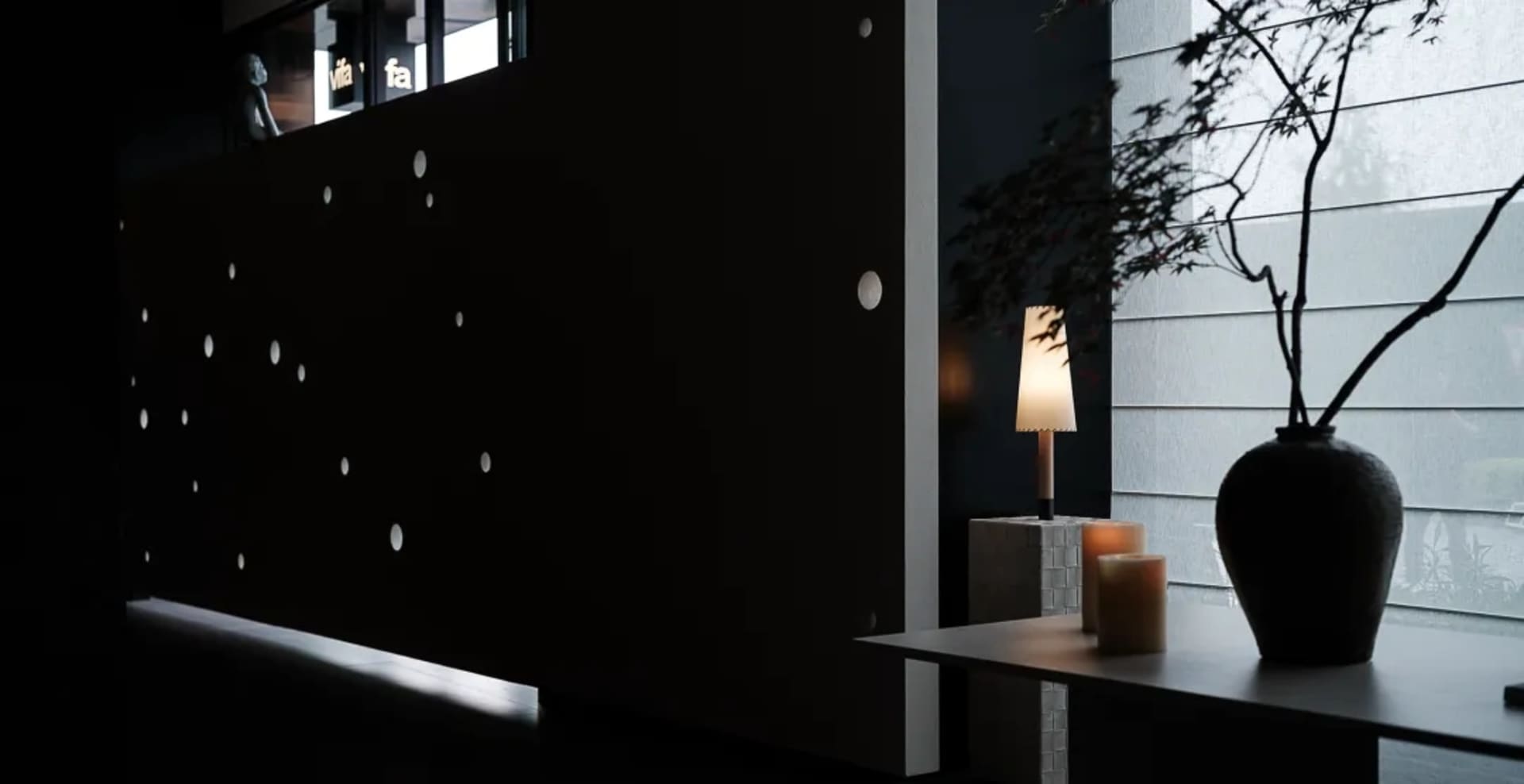 A modern living room featuring a glass wall and a cozy seating area.