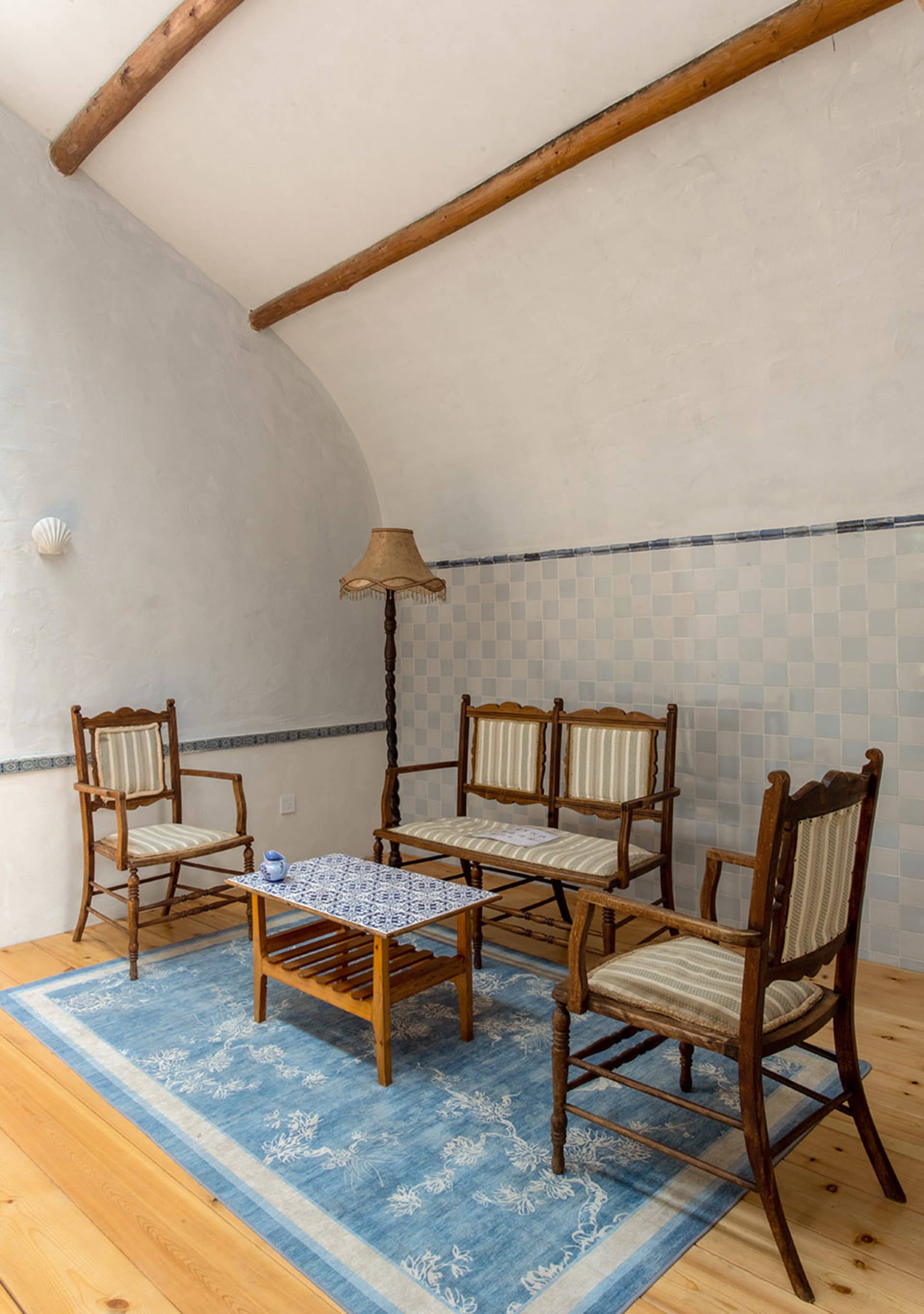 A traditional living room with wooden furniture, tiled walls, and a carpeted floor.