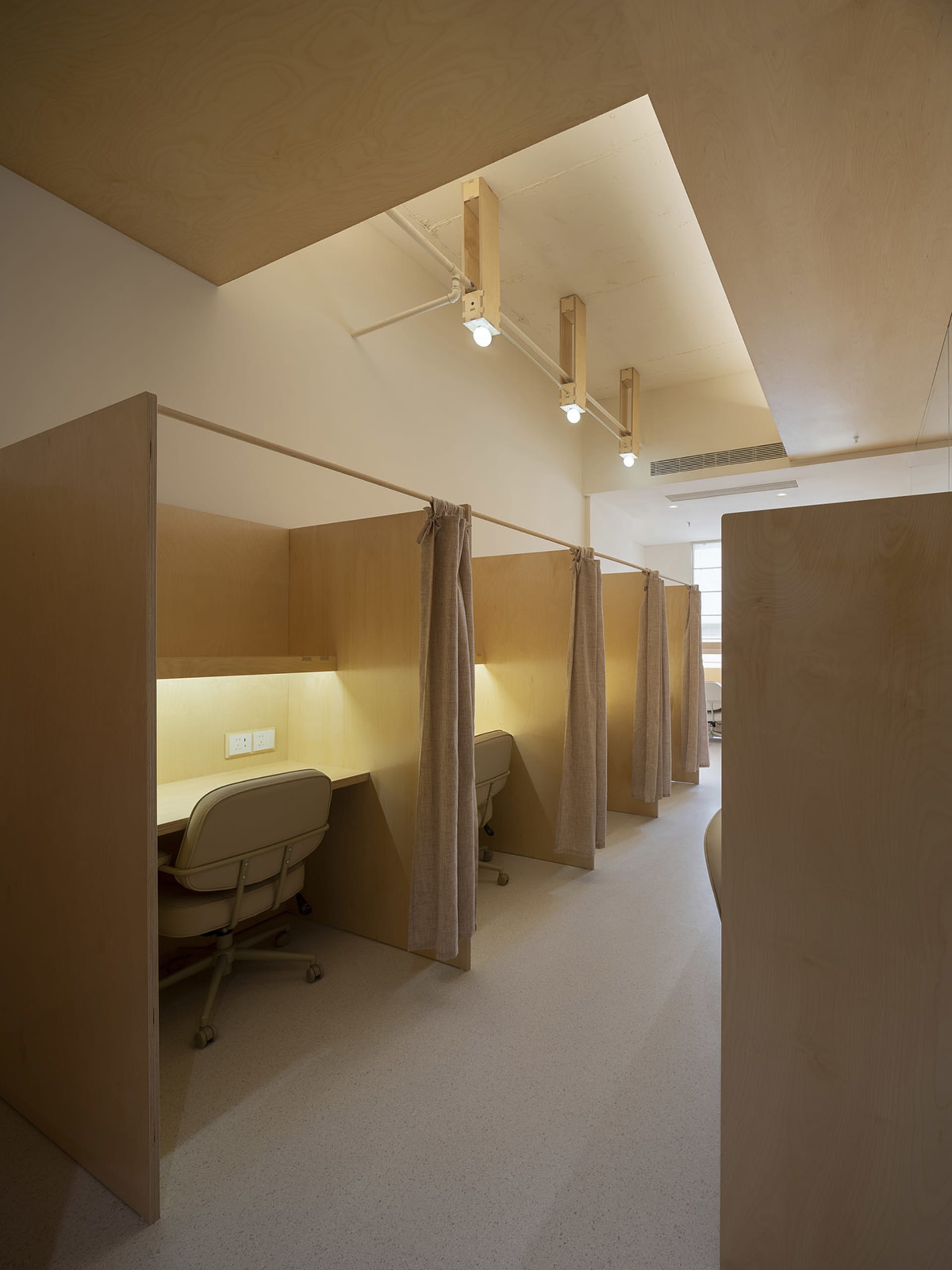 Modern minimalist office cubicles with wood panels and curtains