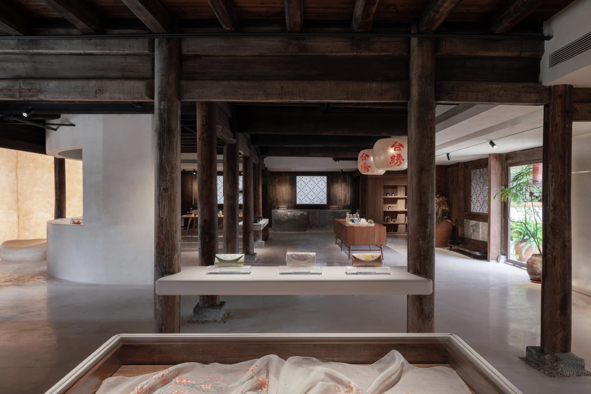 Modern interior space featuring wooden beams and concrete flooring.