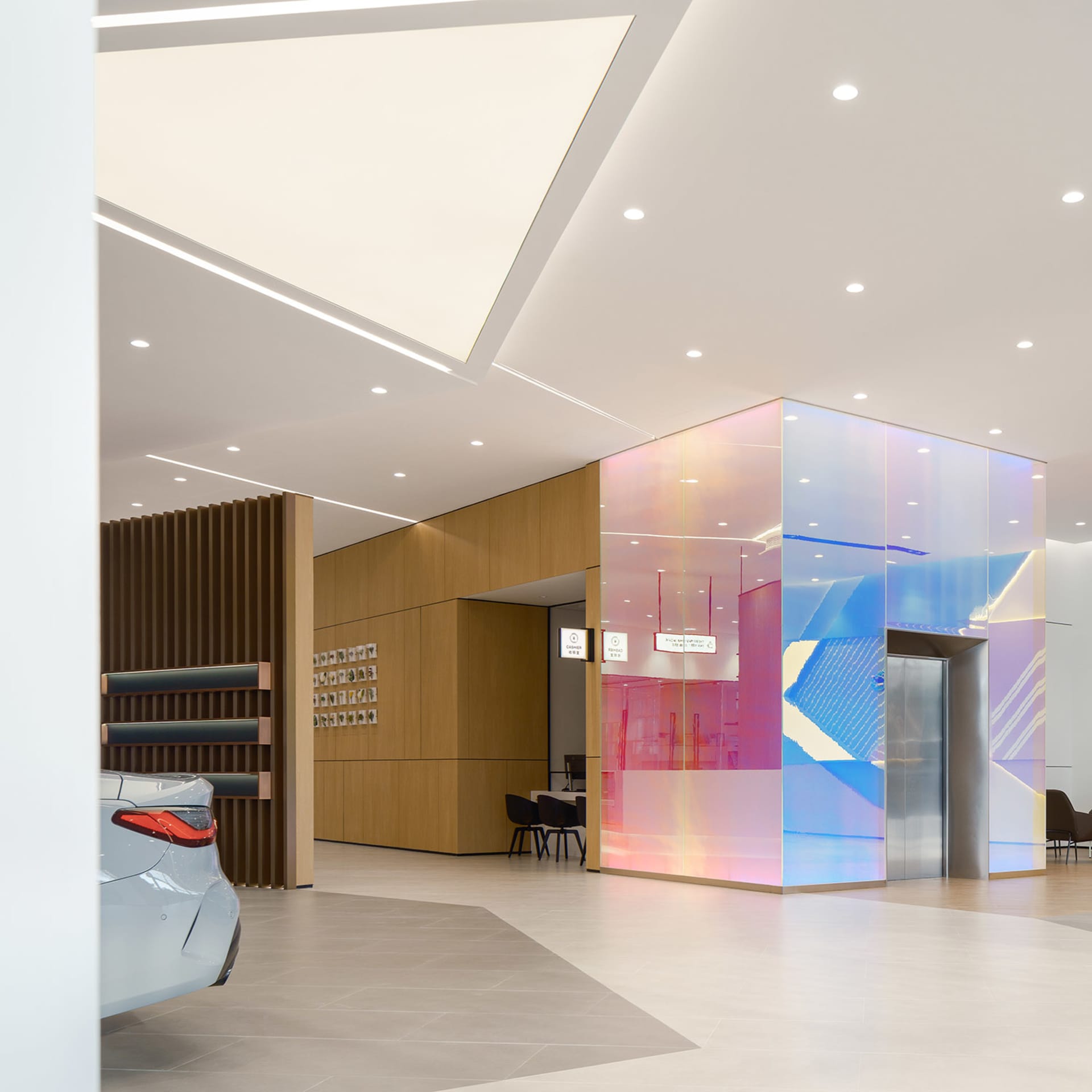 A minimalist showroom featuring colorful glass cladding on the walls.