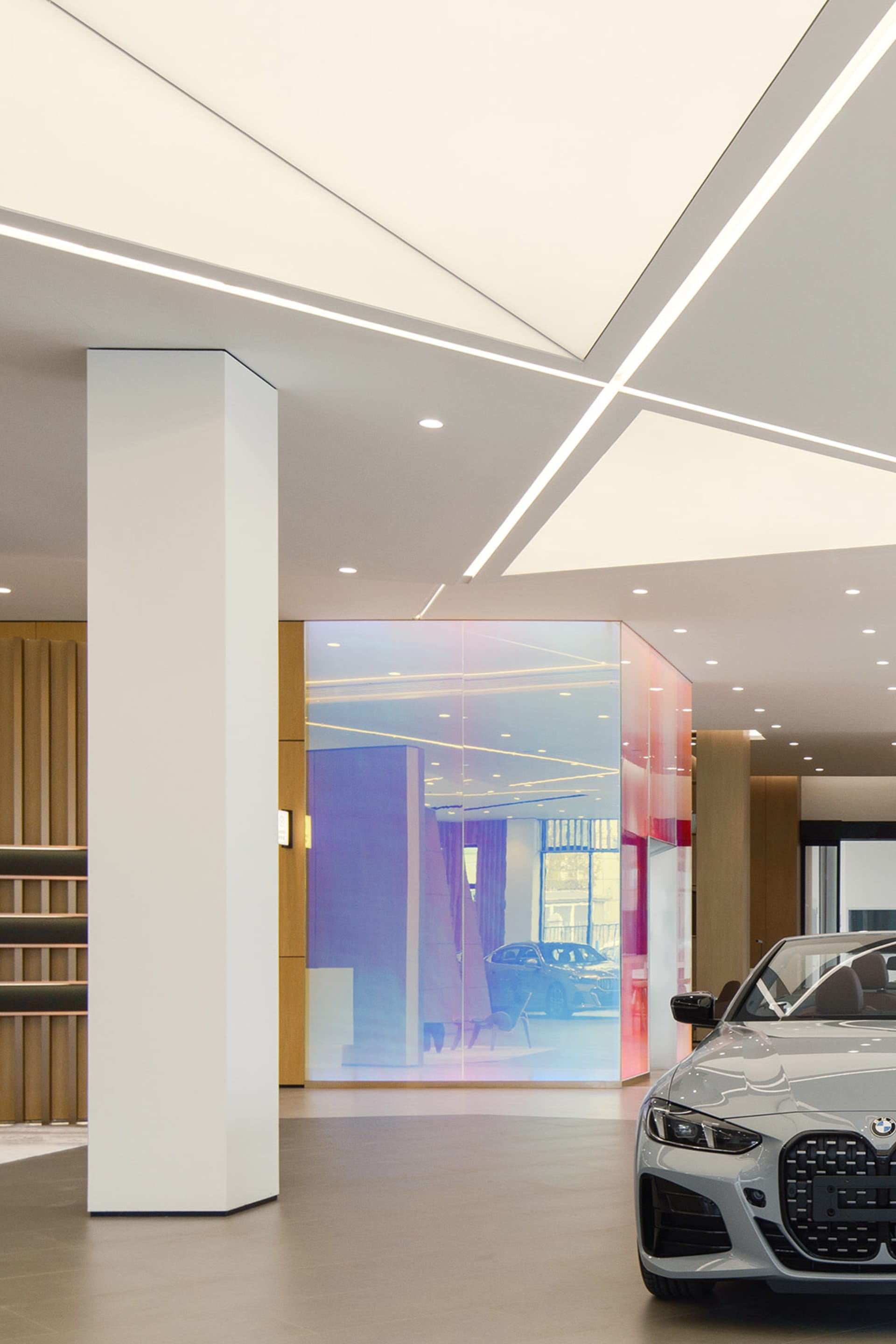 A well-lit, modern car dealership interior with sleek design elements and glass partitions.