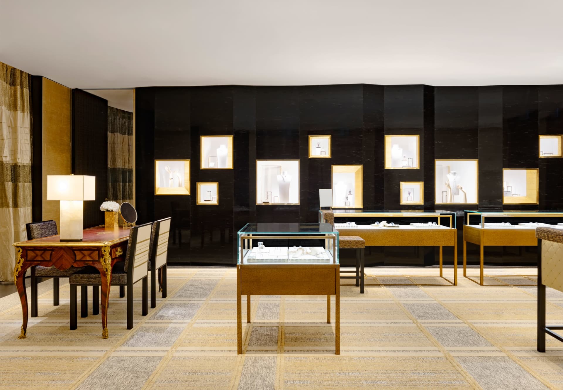 A modern jewelry store with glass cases displaying jewelry, wooden tables, and gold accents.