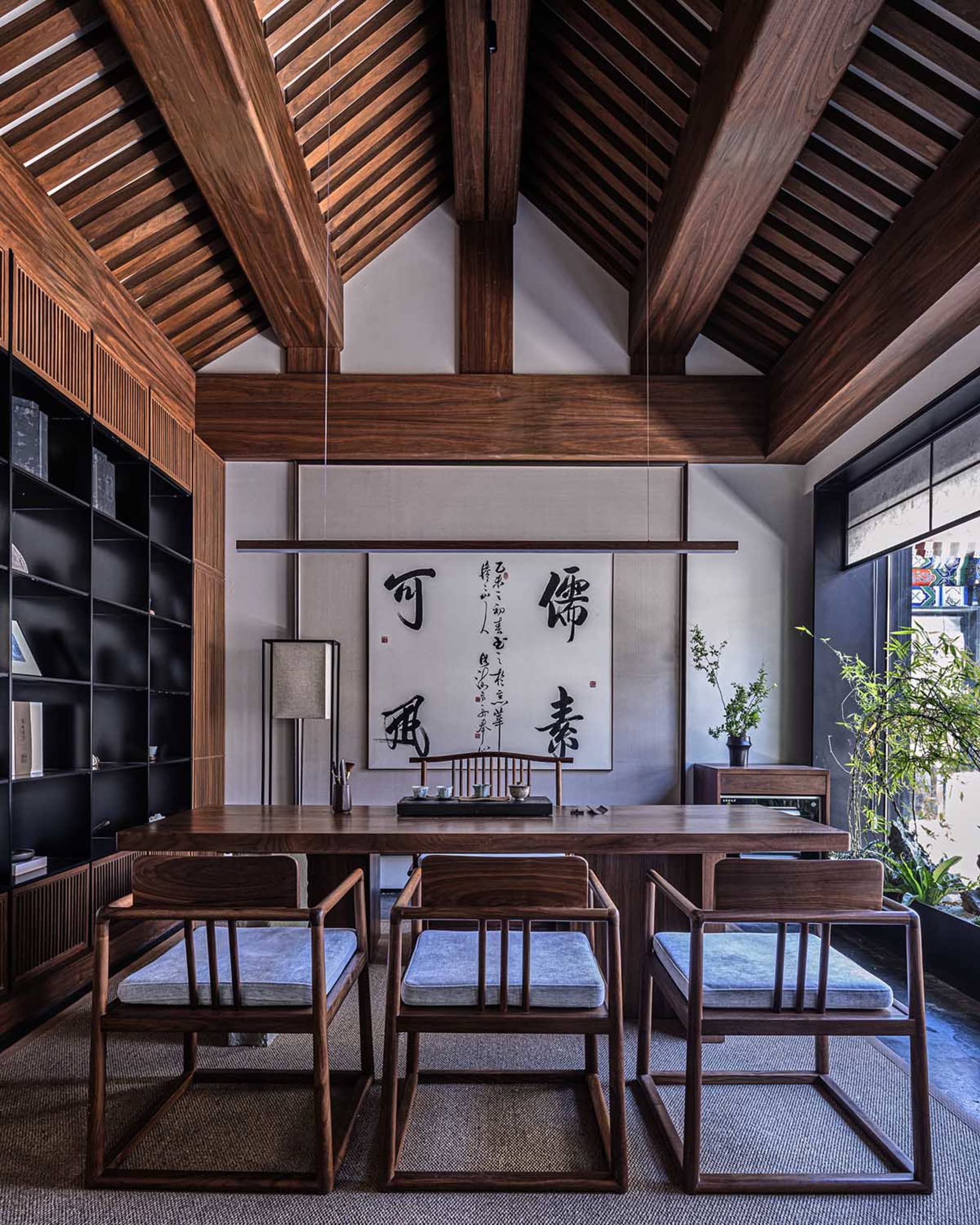 A minimalist study space with wooden furniture and a bookshelf.