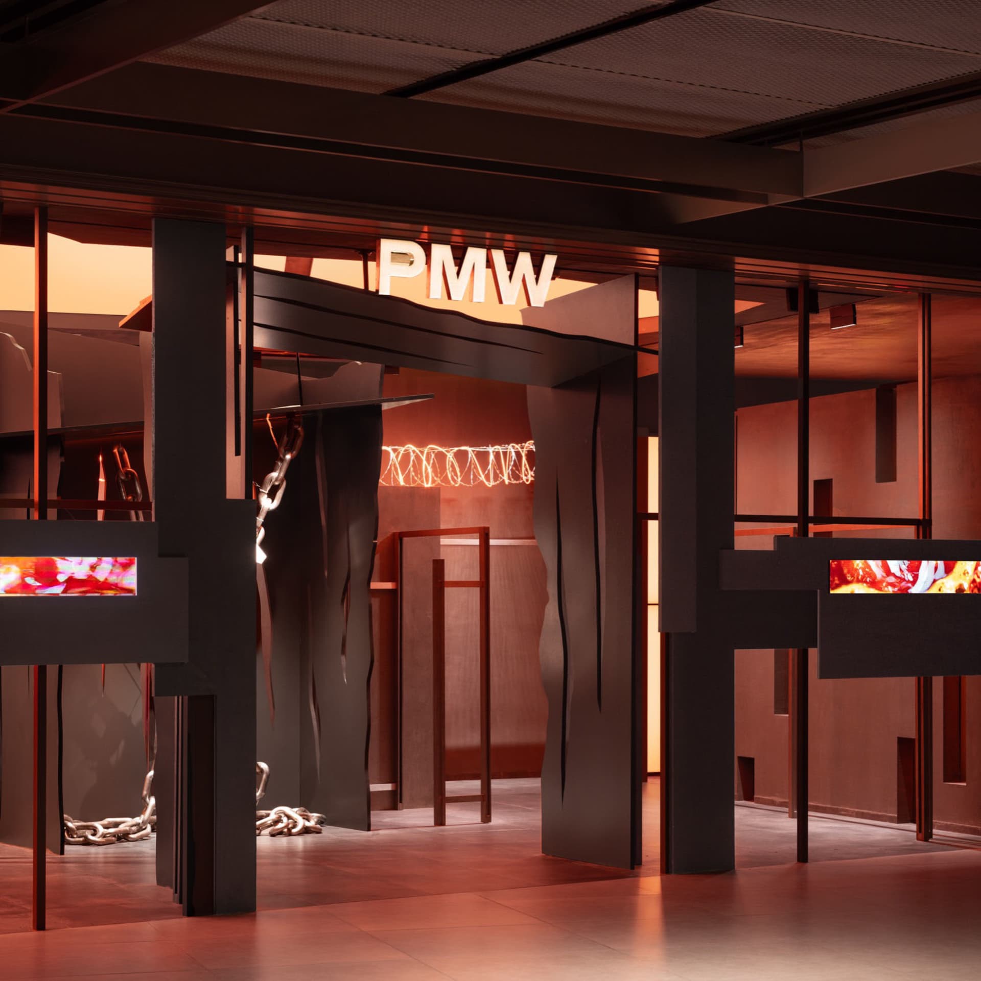 Modern interior design with metal, glass, and wood elements prominently displayed under red lighting.