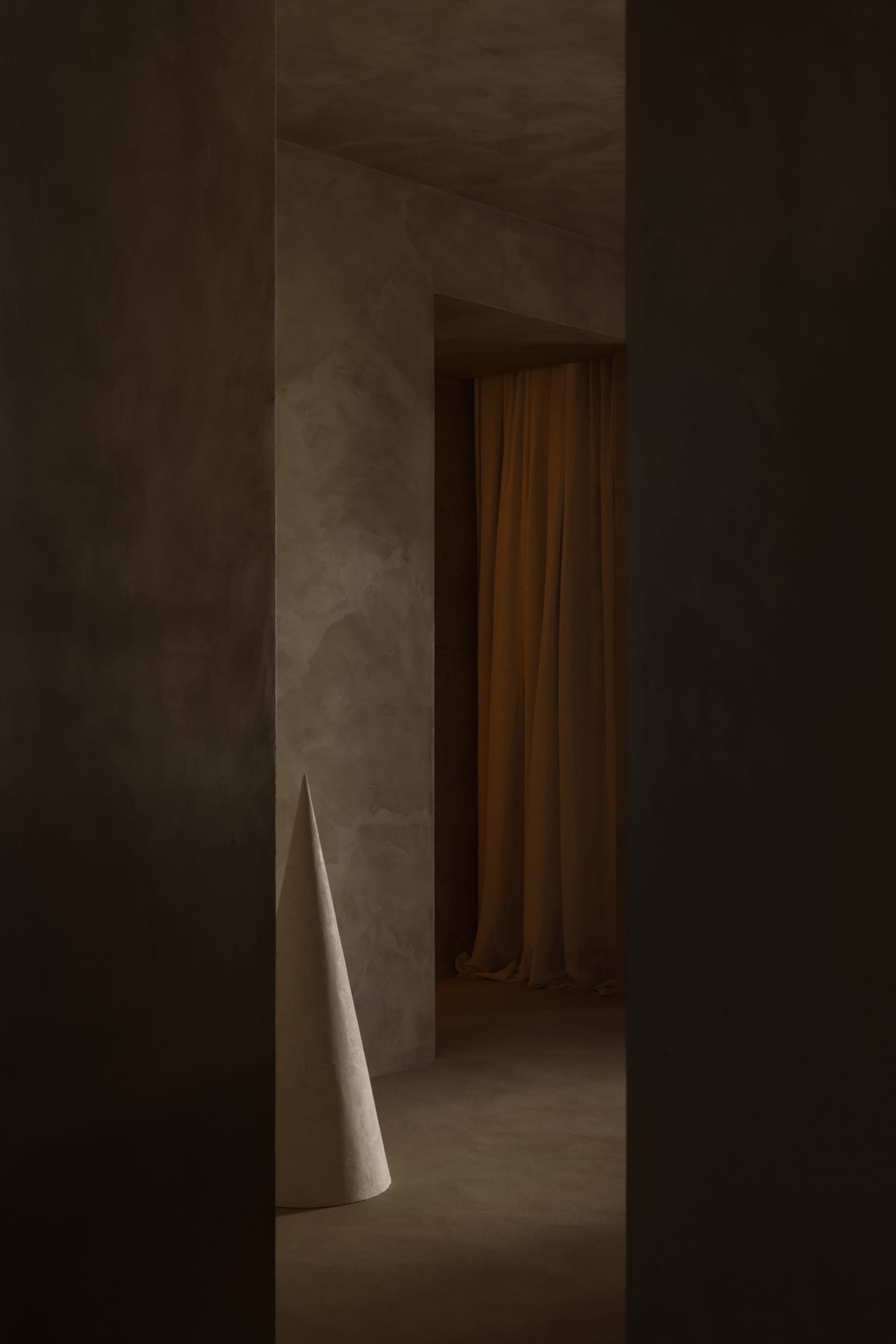 A minimalist space featuring a modern concrete structure within a gray-painted room.