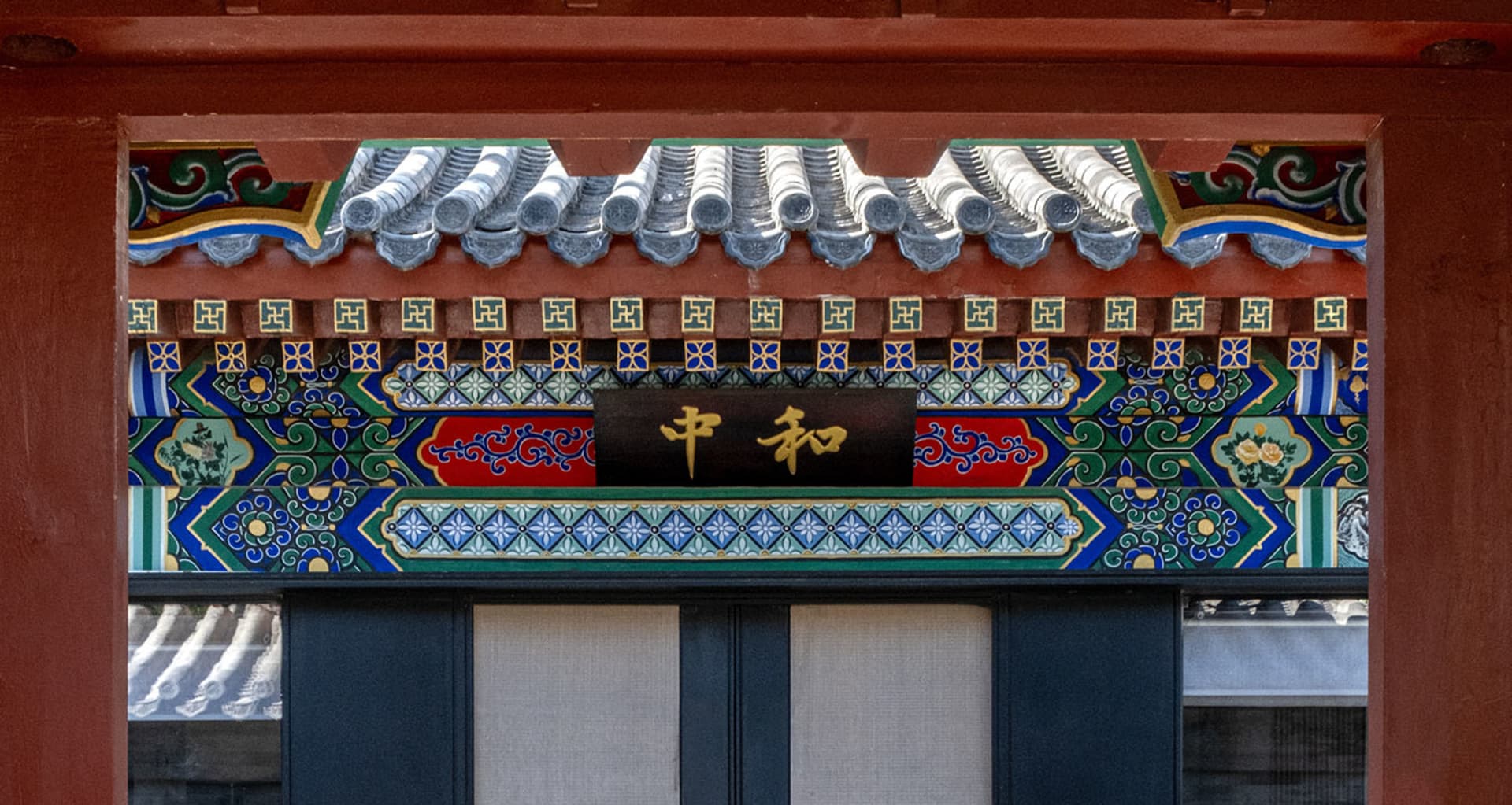 Traditional Japanese architectural doors adorned with colorful ceramic tiles and metal elements, featuring intricate patterns