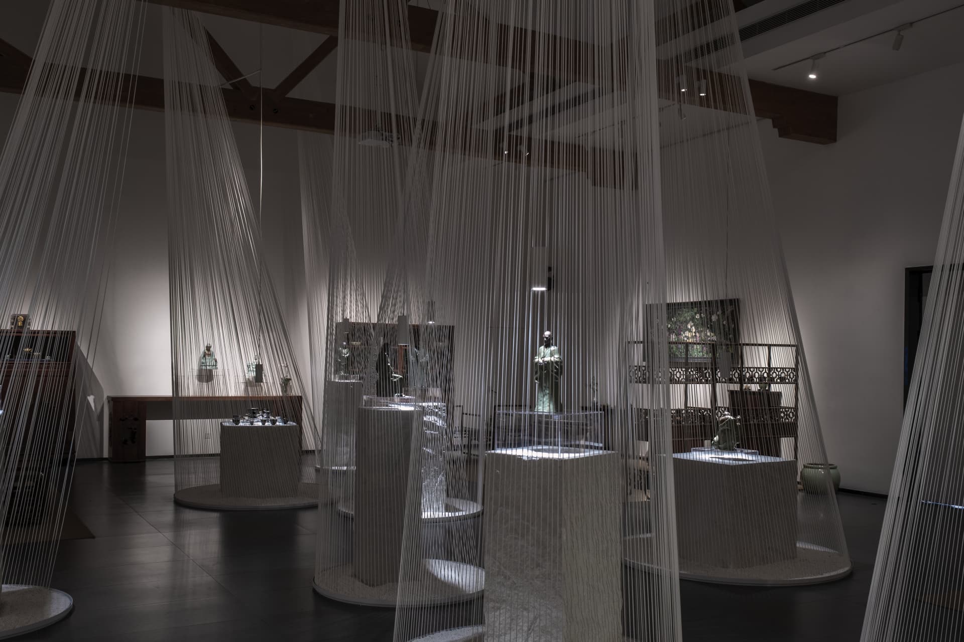 An interior design exhibition featuring a curtain made of thin strings hanging from the ceiling.