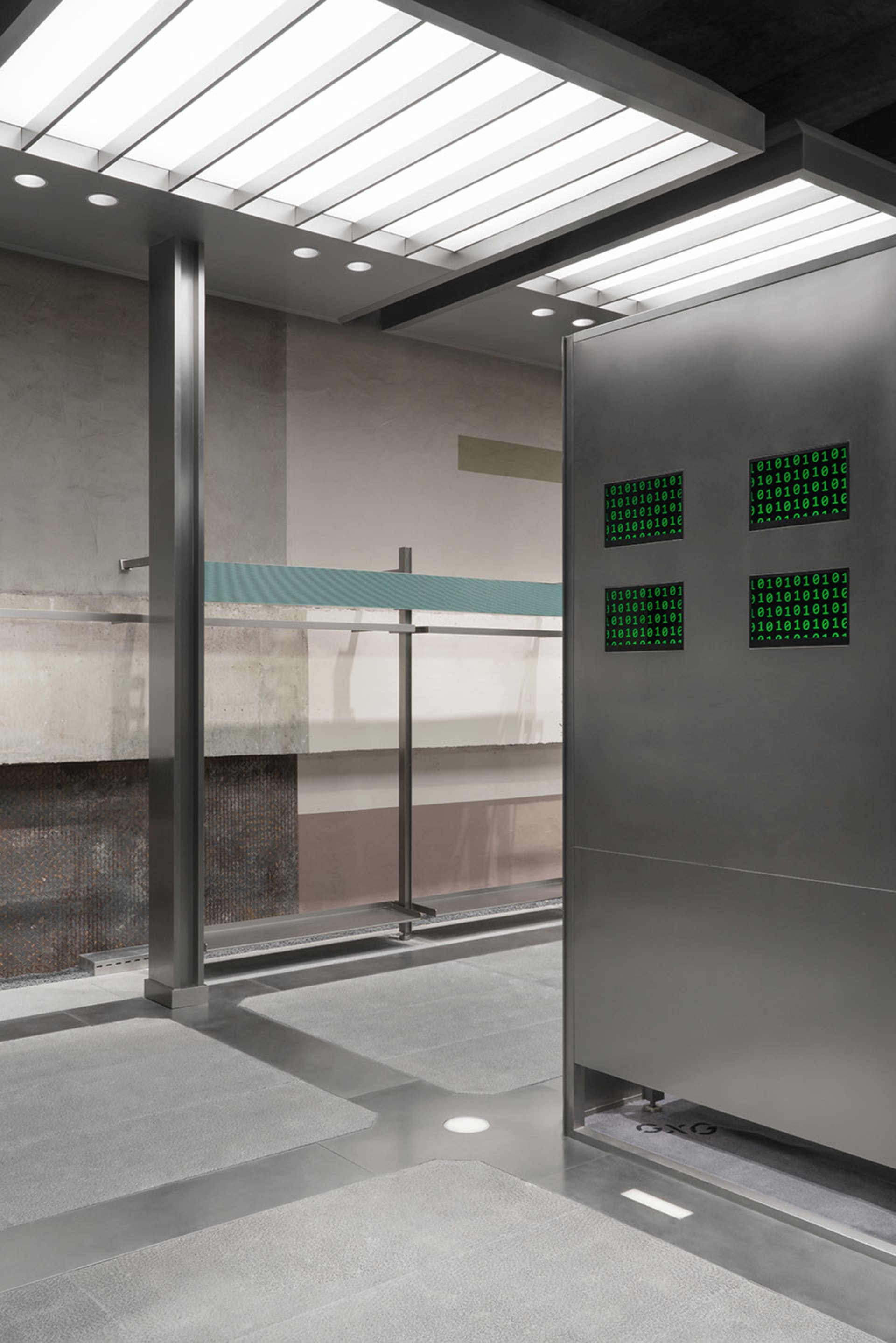Seamless transition between metal and glass panels in a modern commercial space with concrete floor and ceiling.