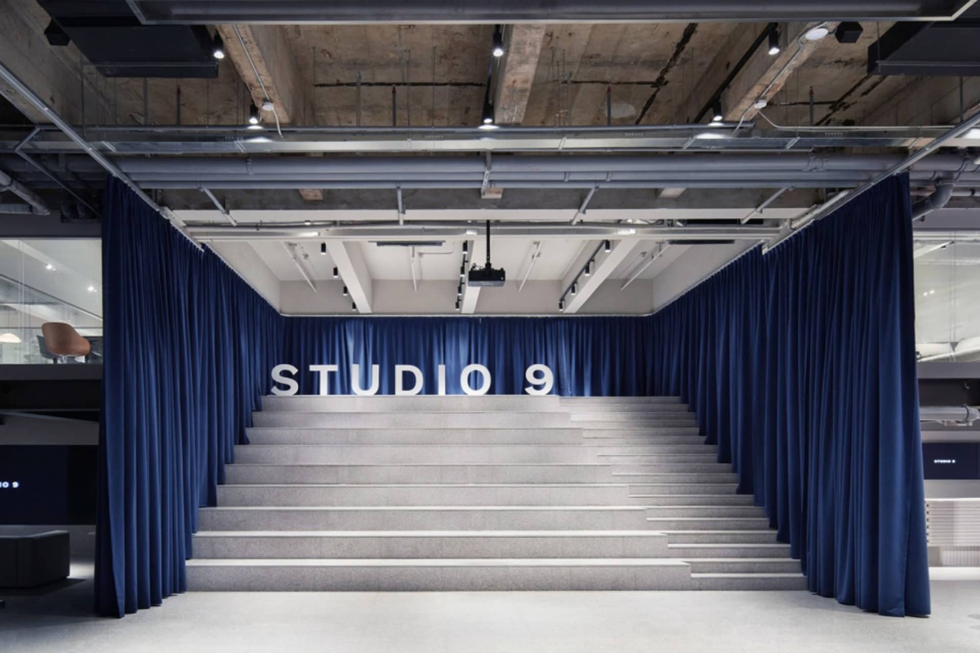 A modern, corporate space featuring granite stairs and blue curtains