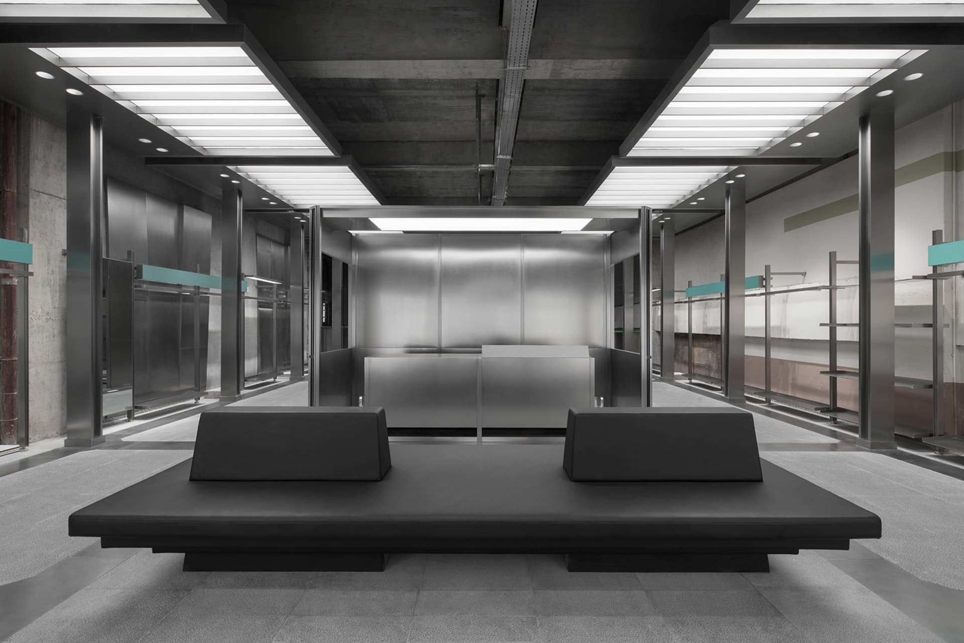 Modern industrial office lobby with metallic surfaces and minimalist design.
