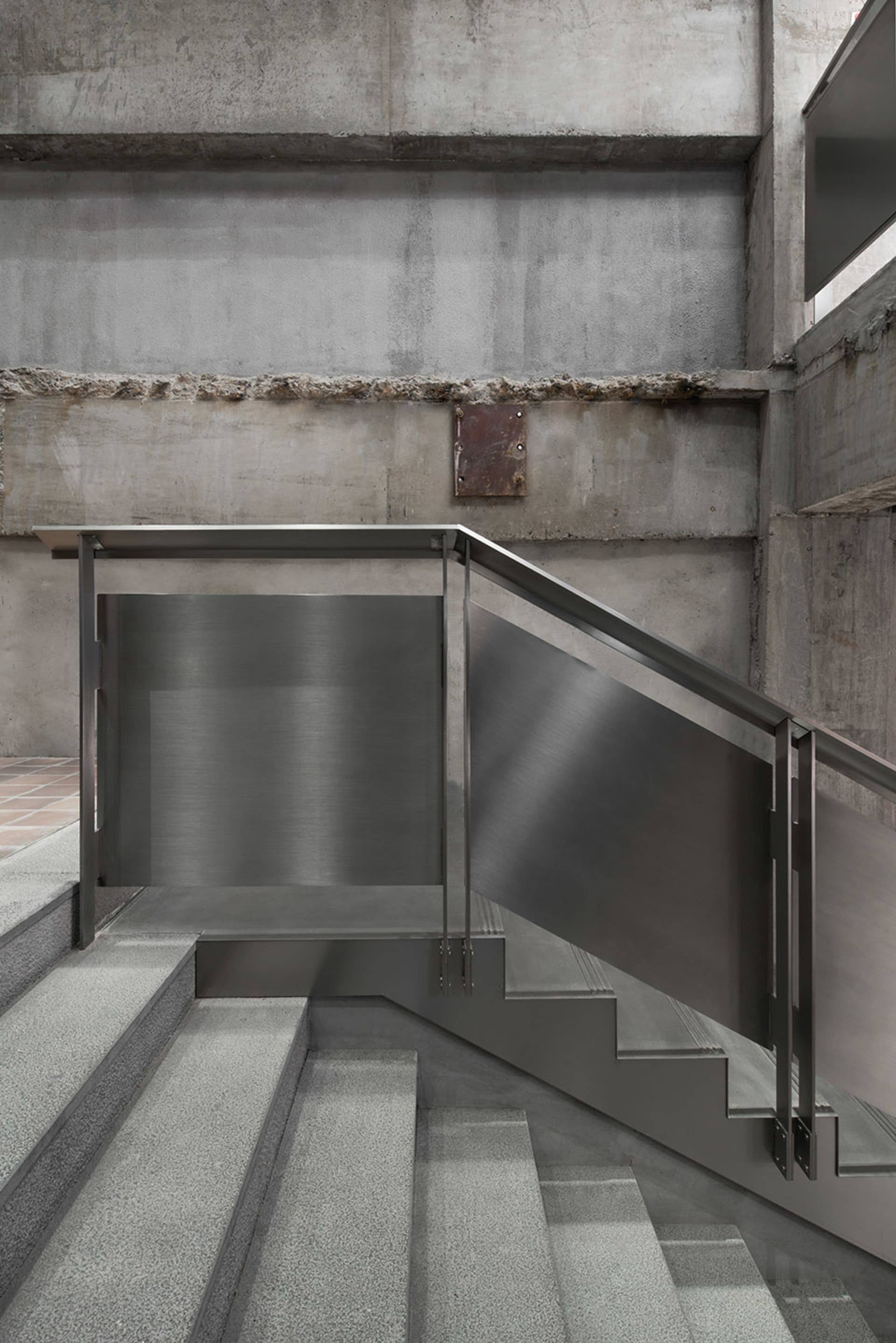 Modern staircase with concrete steps and walls.