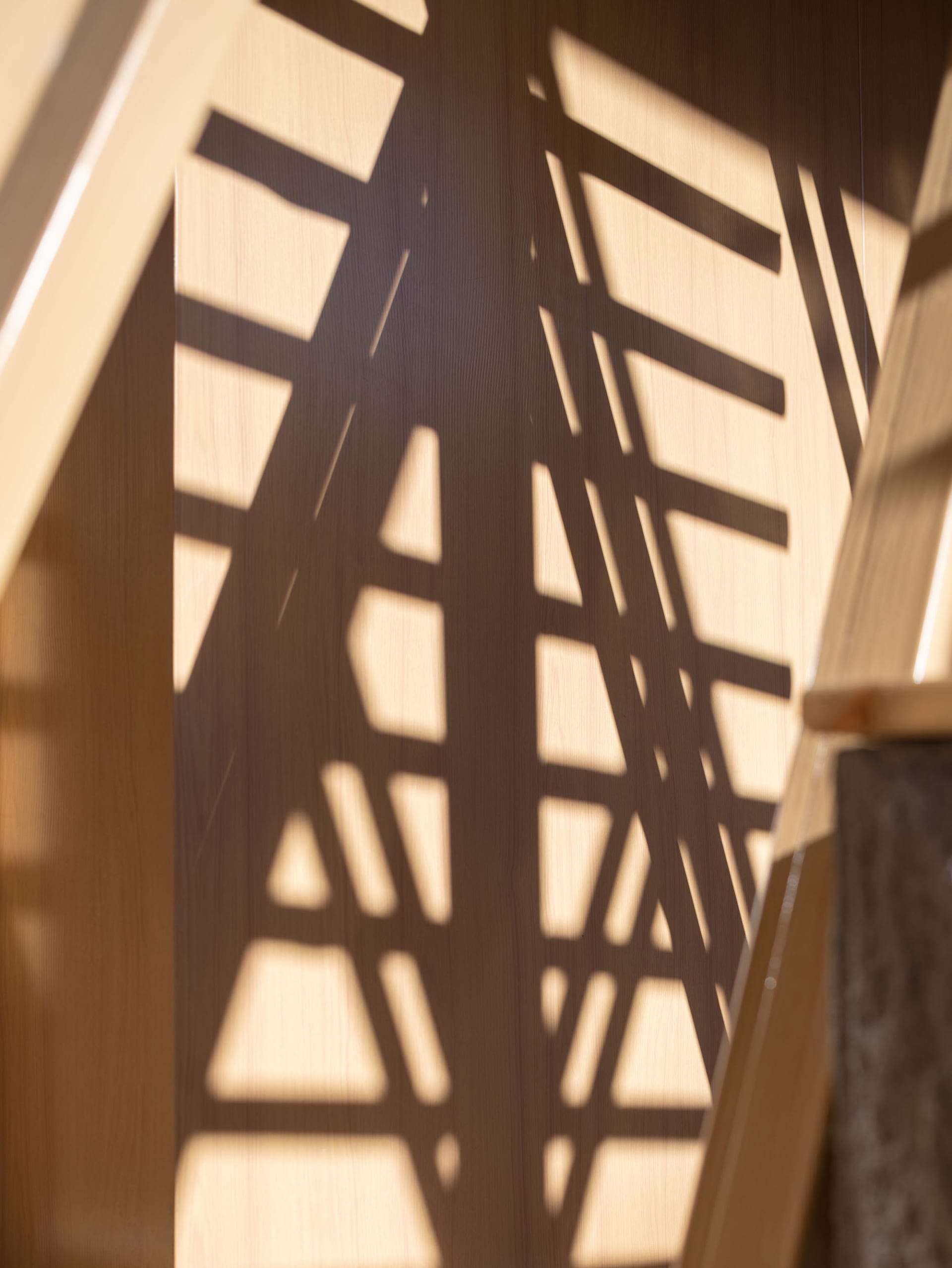 A pattern of light and shadow created by a geometric design on a wall.