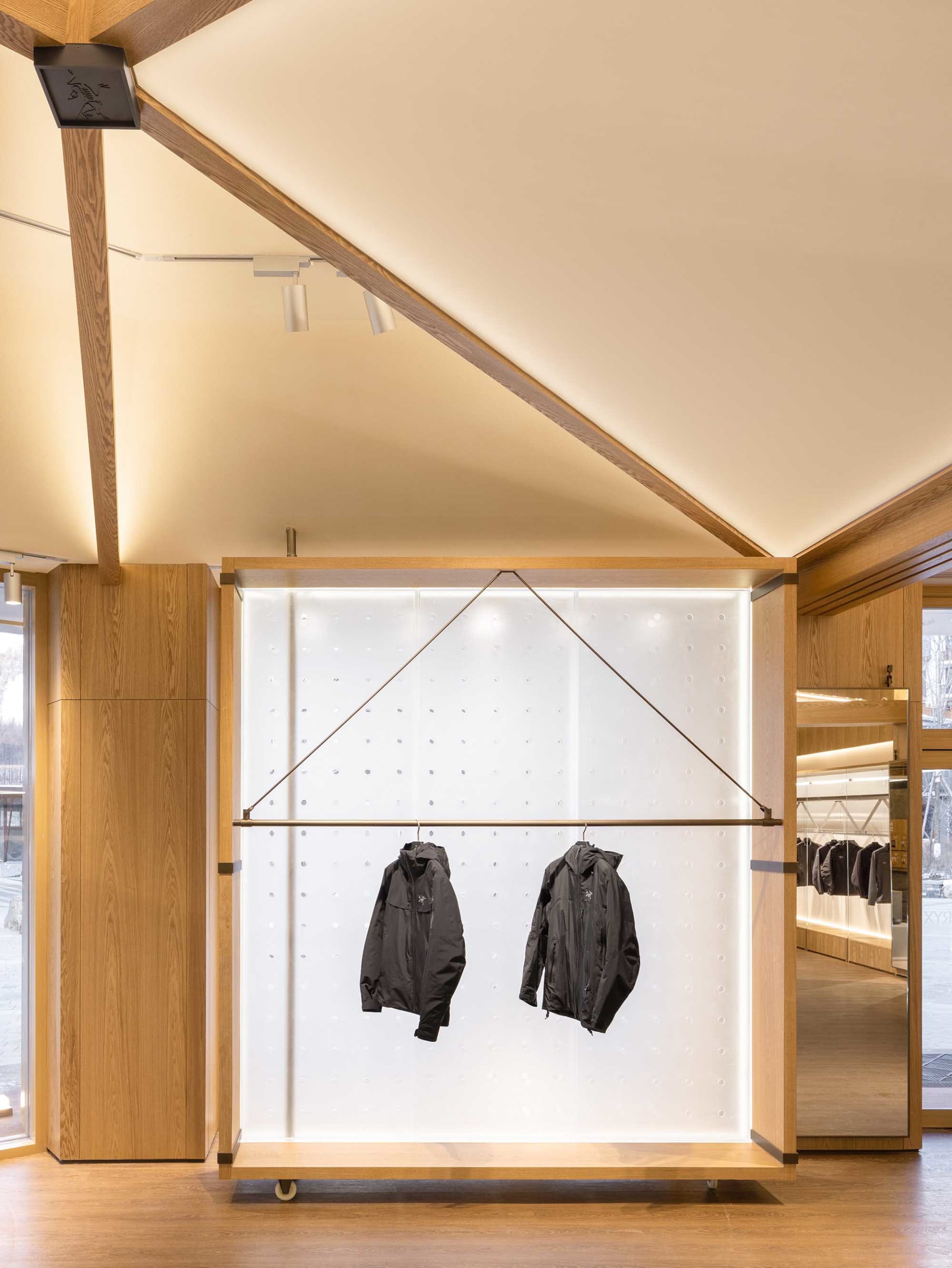 Interior of a clothing store featuring wooden shelving and glass display cases.