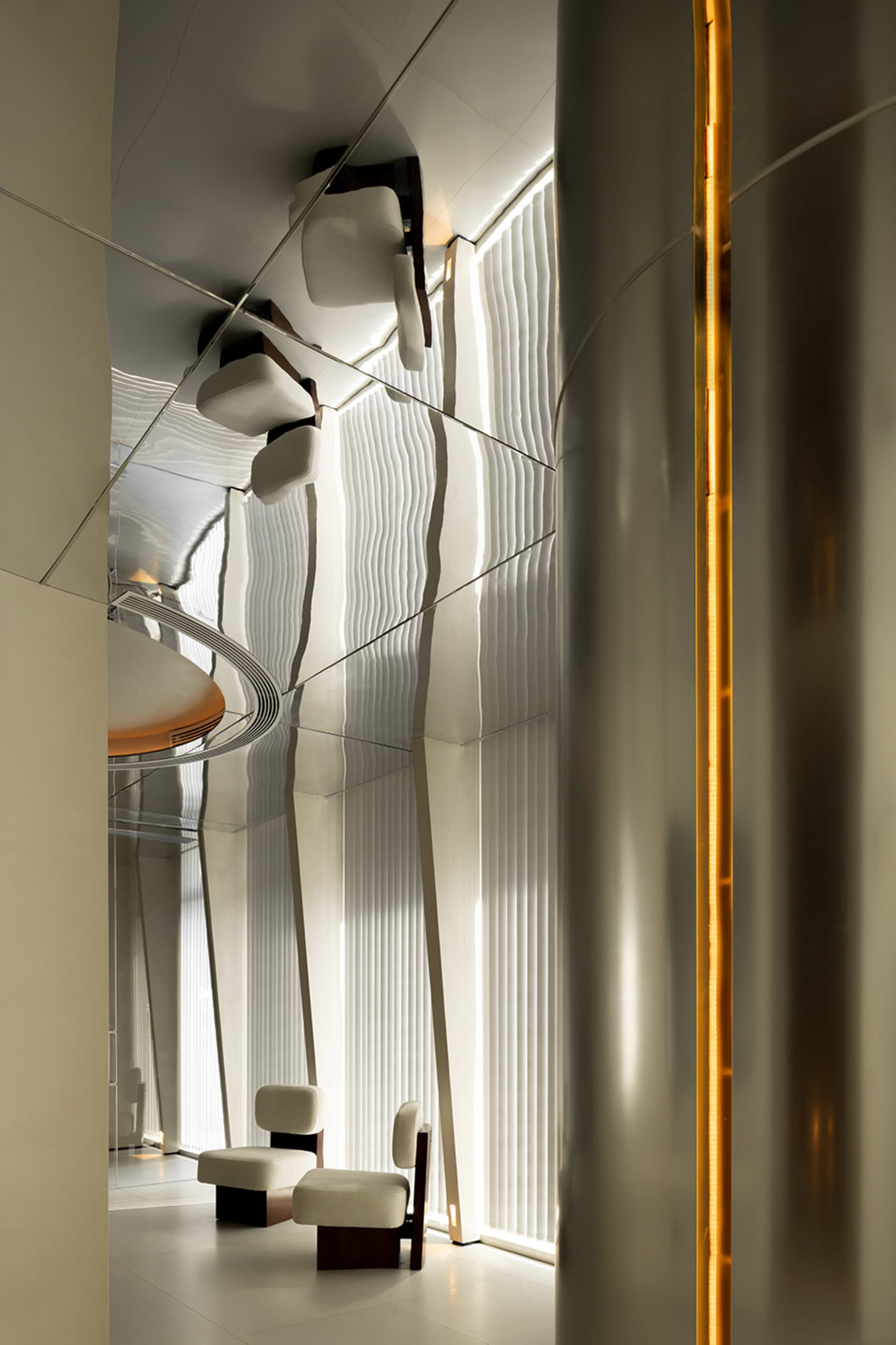 A sleek, modern office lounge area with metallic walls and furniture.