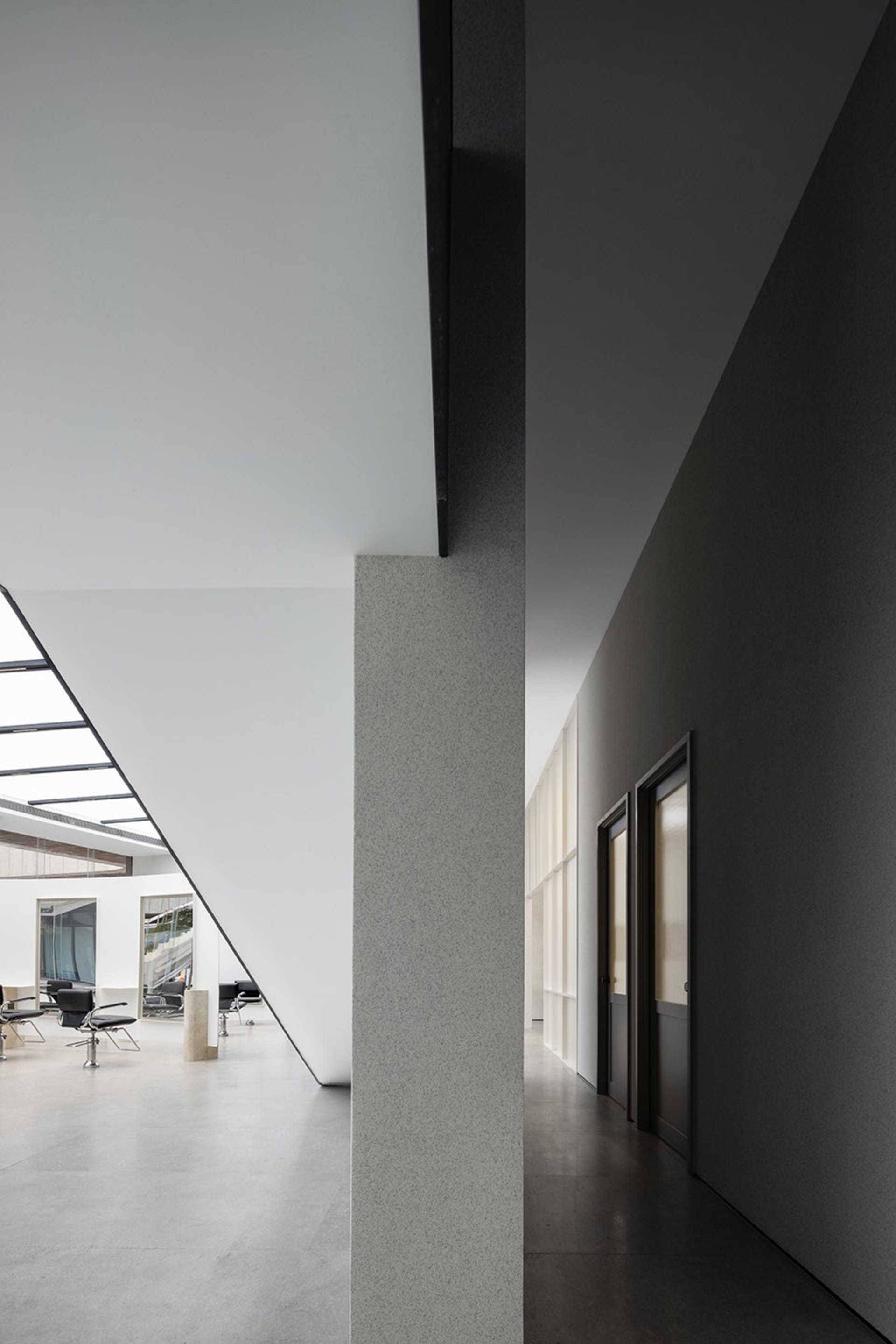 Contemporary office interior featuring minimalist design with concrete structural elements.