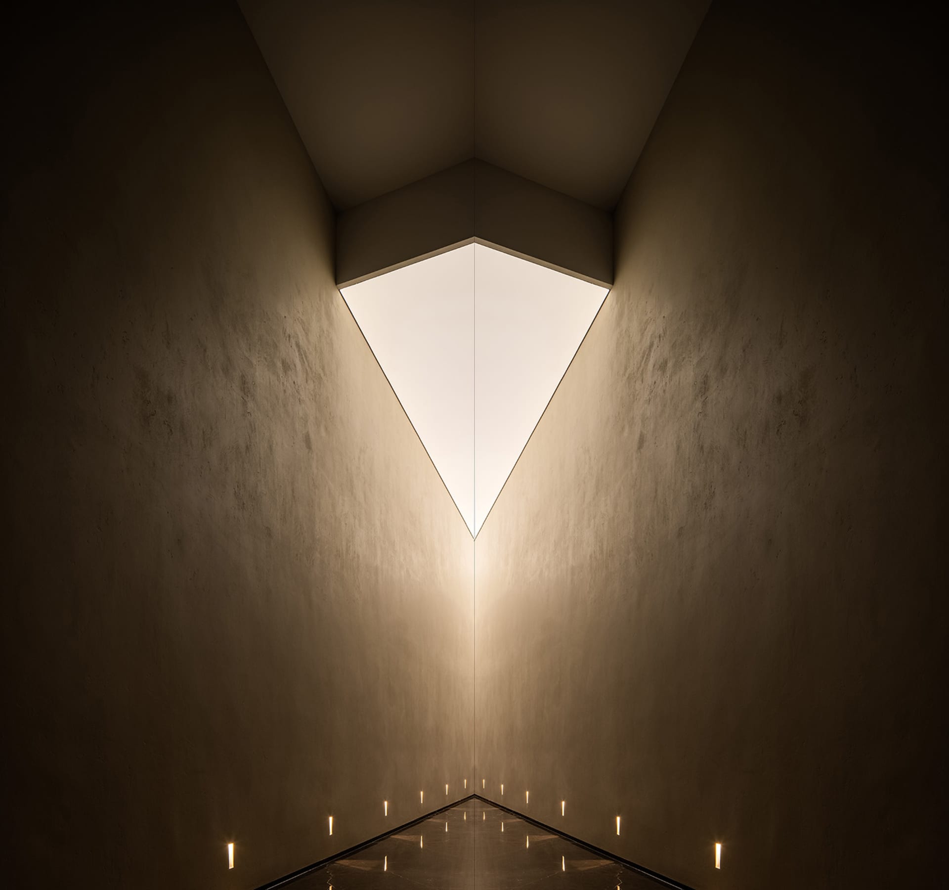A modern interior design featuring contemporary lighting and concrete walls.