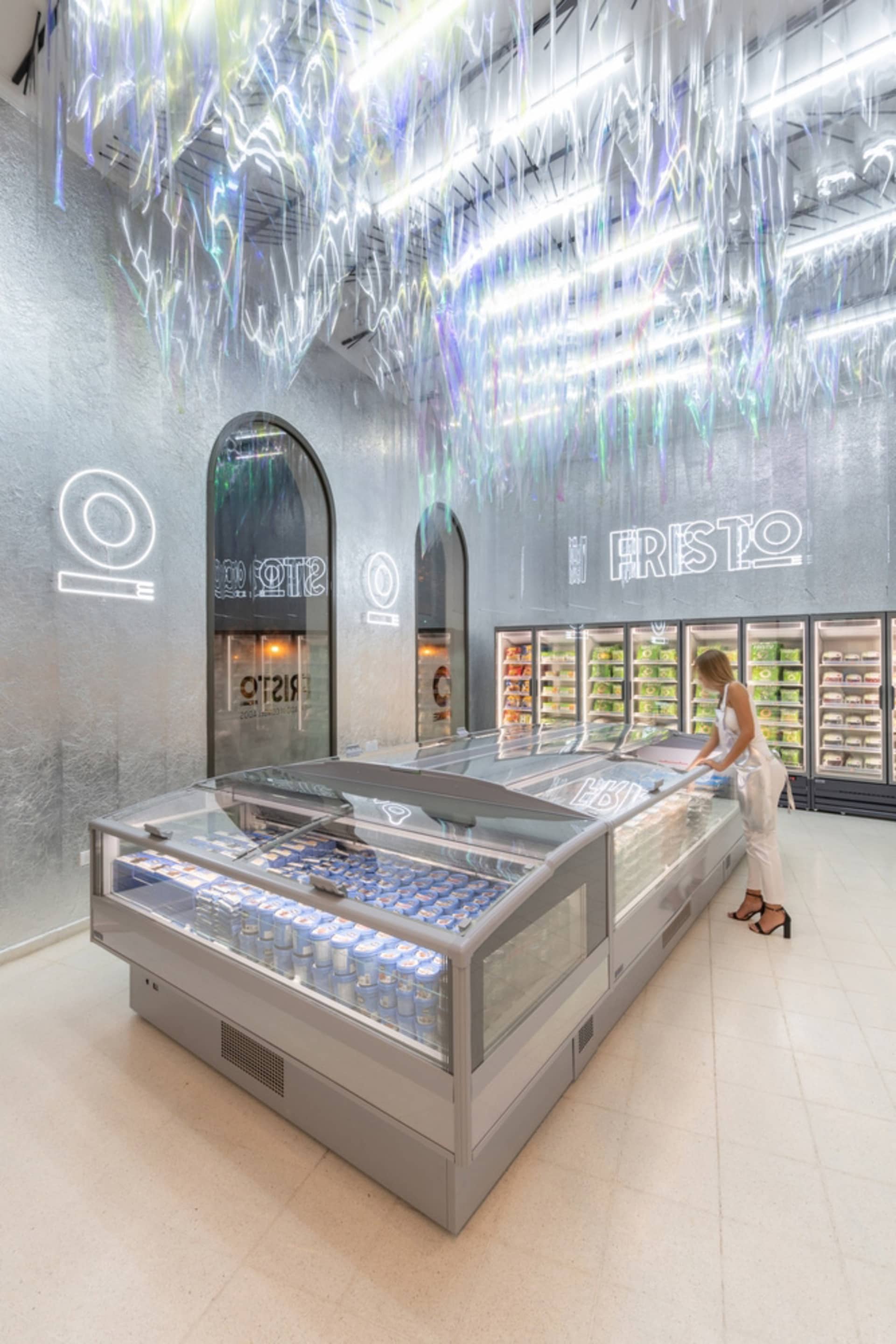A modern grocery store with metallic surfaces and illuminated displays.